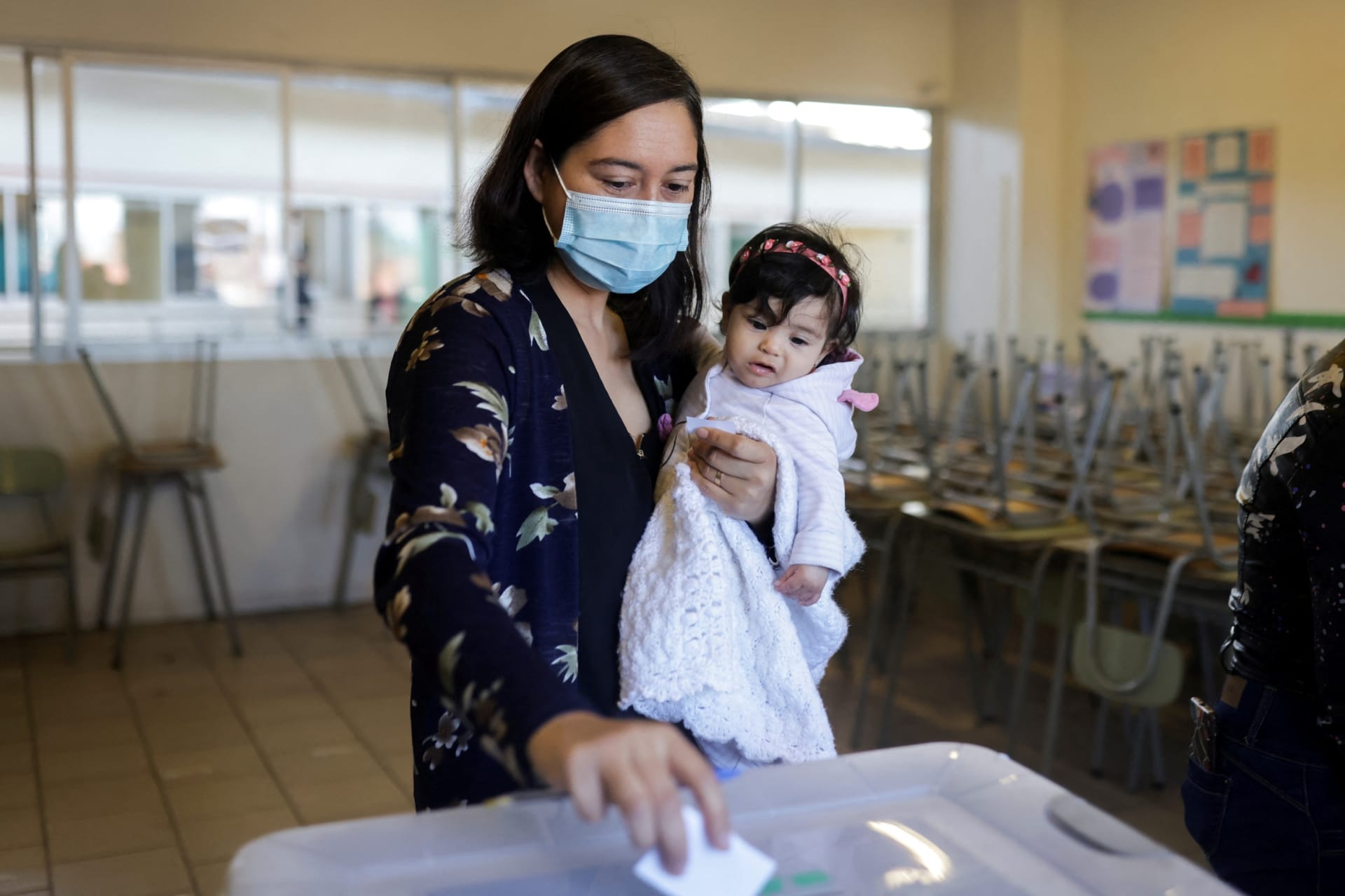 <p>A woman holding a baby in Santiago, Chile, September 4, 2022.</p>
