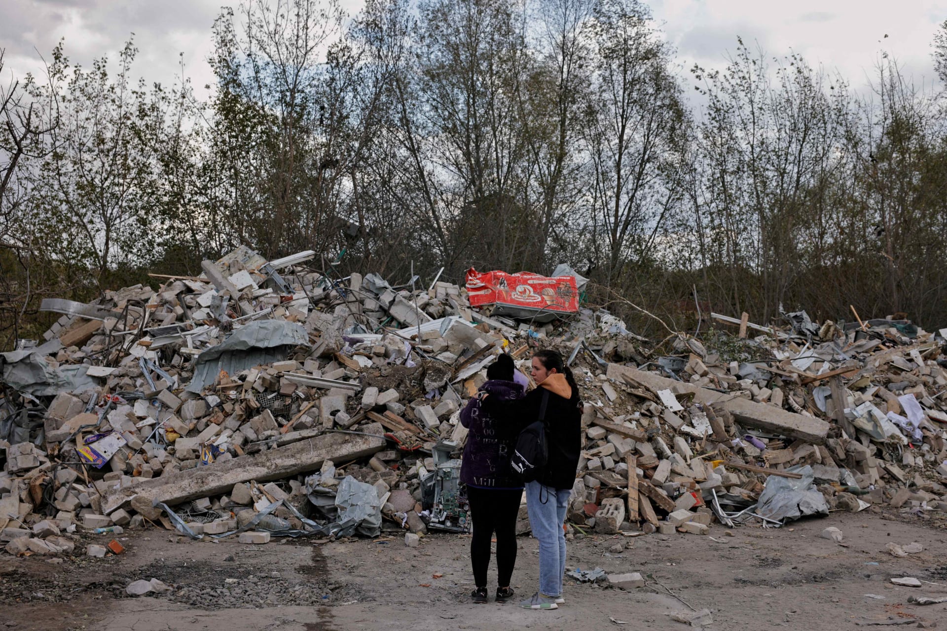 <p>Two women react in front of a pile of rubble that is left of the cafe that hosted the wake and was hit by a Russian missile, following a Russian military strike, amid Russia’s attack on Ukraine, in the village of Hroza, Kharkiv region, Ukraine October 6, </p>

