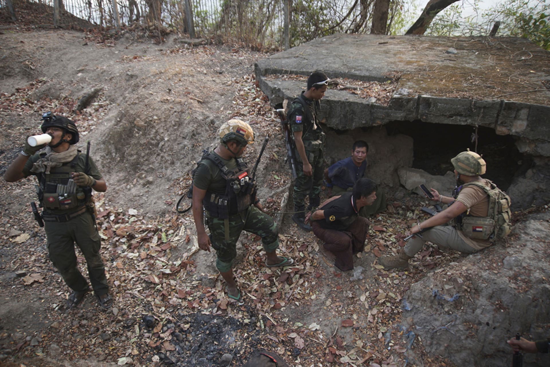 <p>Members of the Karen National Liberation Army and People’s Defense Force examine two arrested soldiers after they captured an army outpost in the southern part of Myawaddy township in Kayin state, Myanmar, on March 11, 2024.</p>
