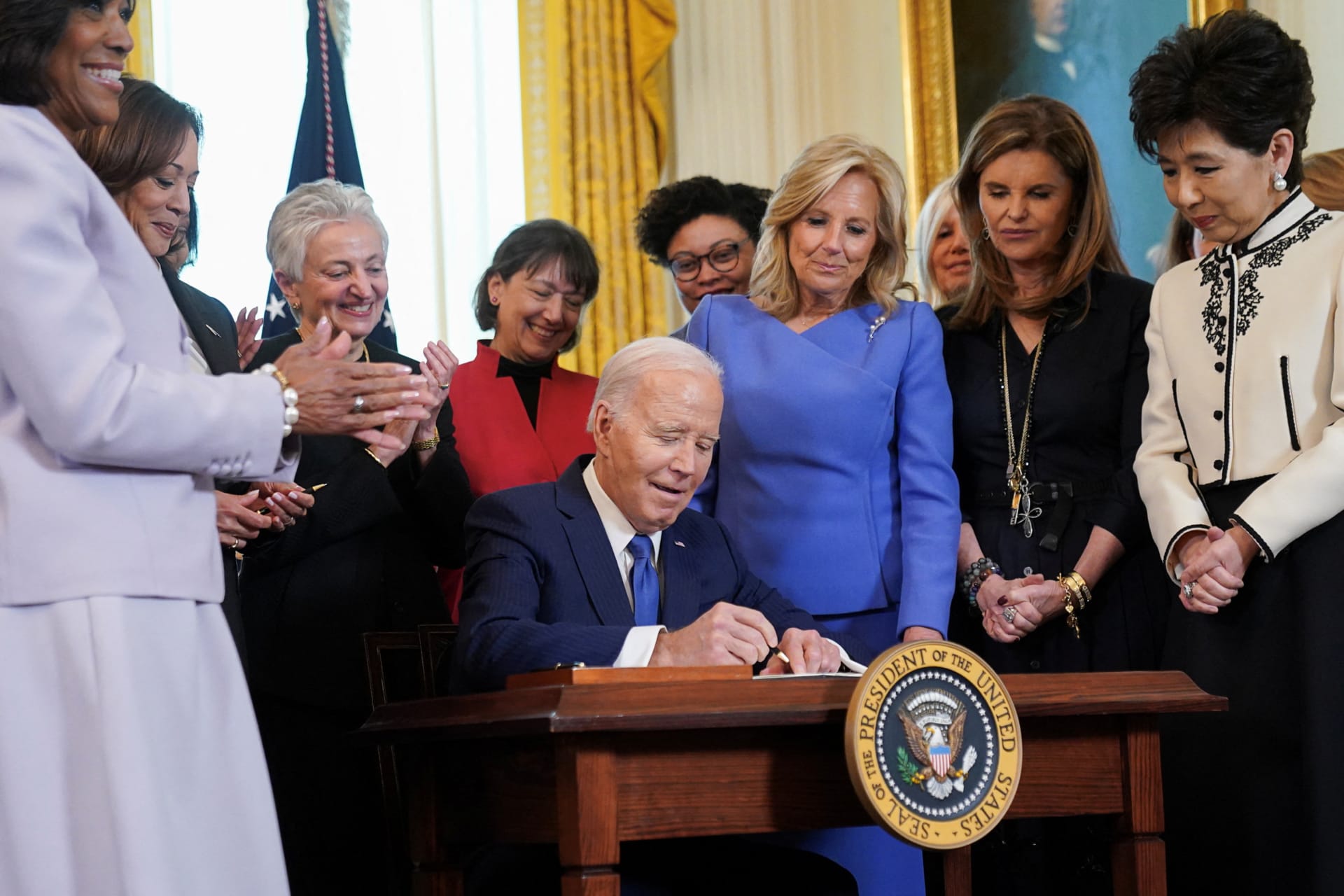 <p>Fitst lady Jill Biden and Maria Shriver look on as U.S. President Joe Biden signs an executive order expanding women’s healthcare at a ceremony in the White House during Women’s History Month</p>

