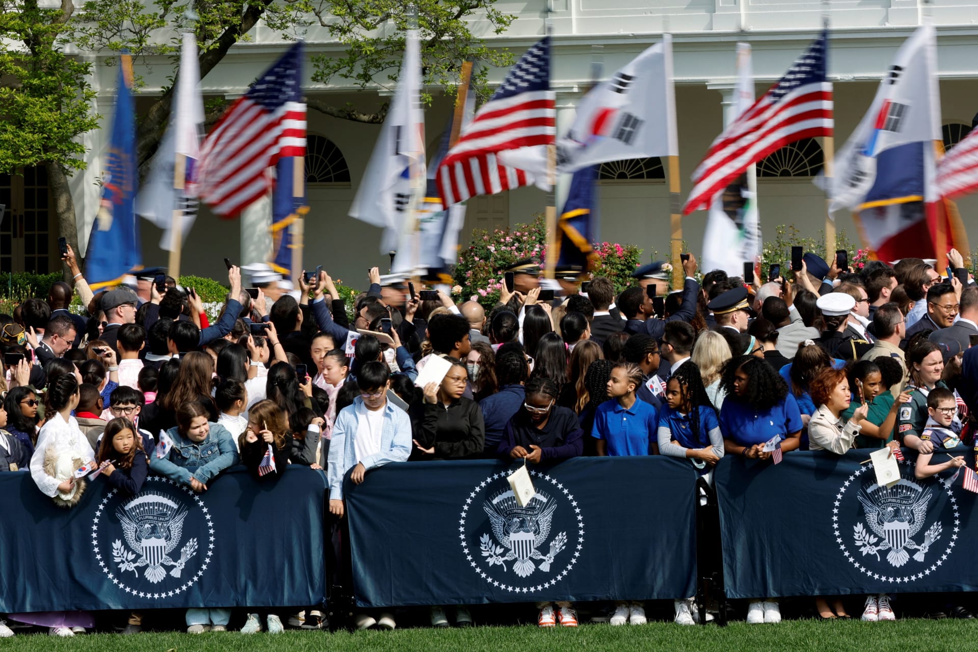 <p>Military personnel carry U.S. and South Korean flags as people wait for an official state arrival ceremony for South Korean President Yoon Suk Yeol at the White House on April 26, 2023. </p>
