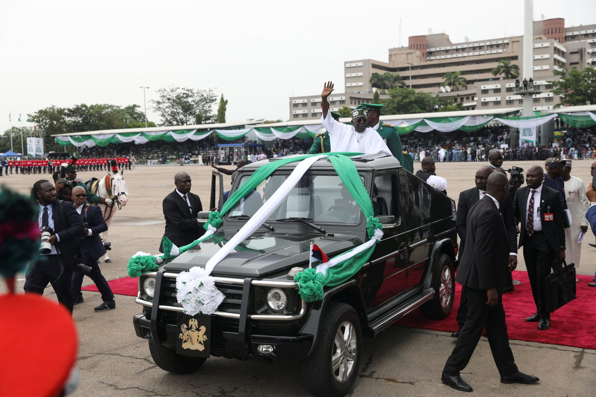 <p>Nigeria’s President Bola Tinubu waves to the crowd as he takes a drive on a top of a sports utility vehicle after his swearing-in ceremony in Abuja, Nigeria, on May 29, 2023.</p>

