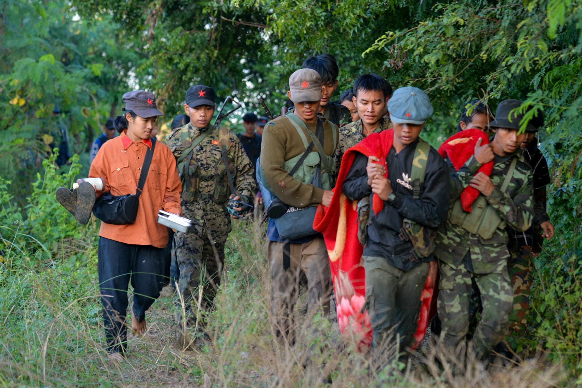 <p>People’s Liberation Army members carry an injured person as they fight the Myanmar junta army near the Sagaing Region on November 23, 2023.</p>
