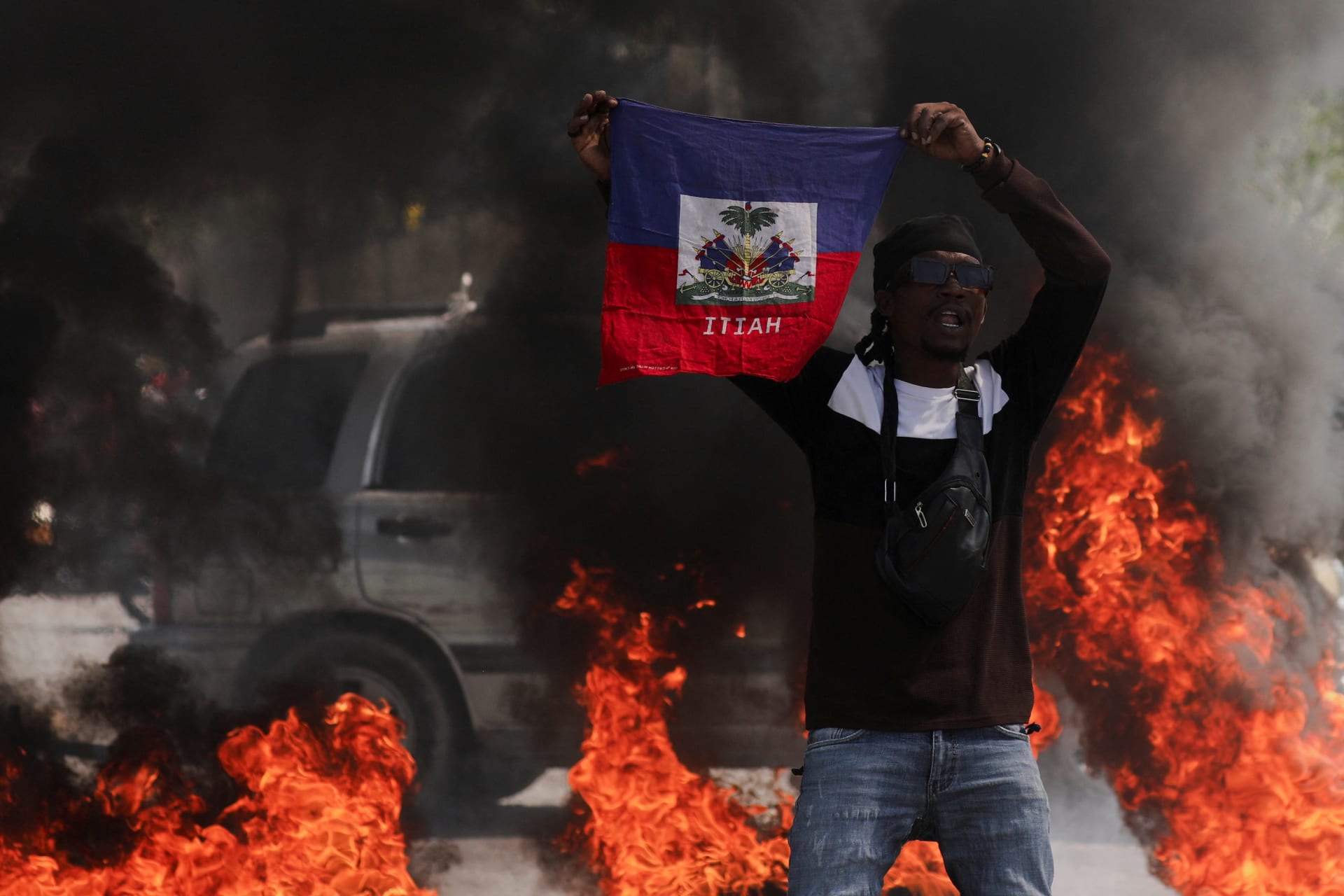 <p>A protestor holds up a Haitian flag during a demonstration against Prime Minister Ariel Henry’s government and insecurity in Port-au-Prince on March 1, 2024.</p>
