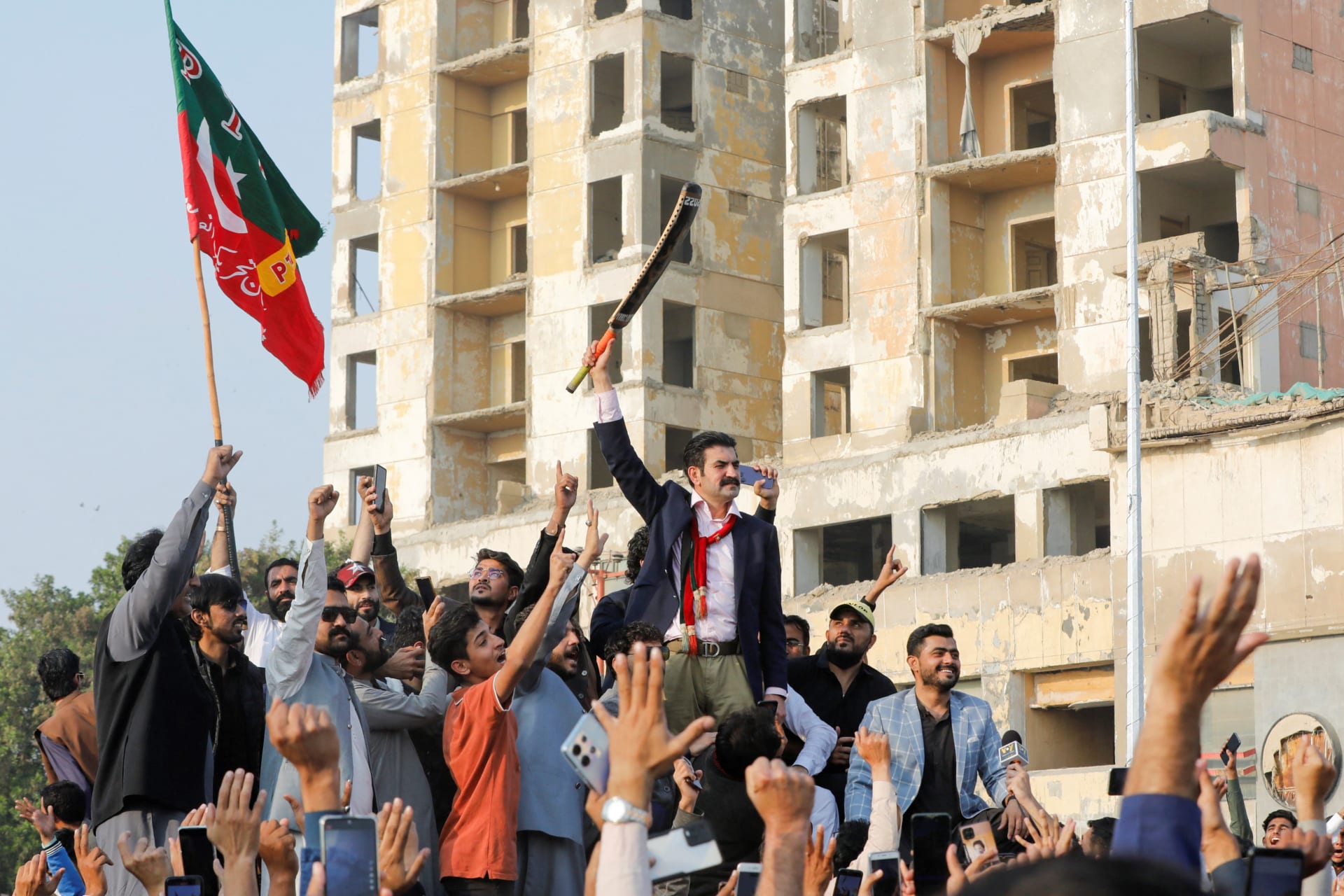 <p>Leader of Pakistan Tehreek-e-Insaf (PTI) Sher Afzal Khan Marwat waves a cricket bat while speaking to supporters during a rally ahead of general elections in Karachi, Pakistan, on January 14, 2024.</p>
