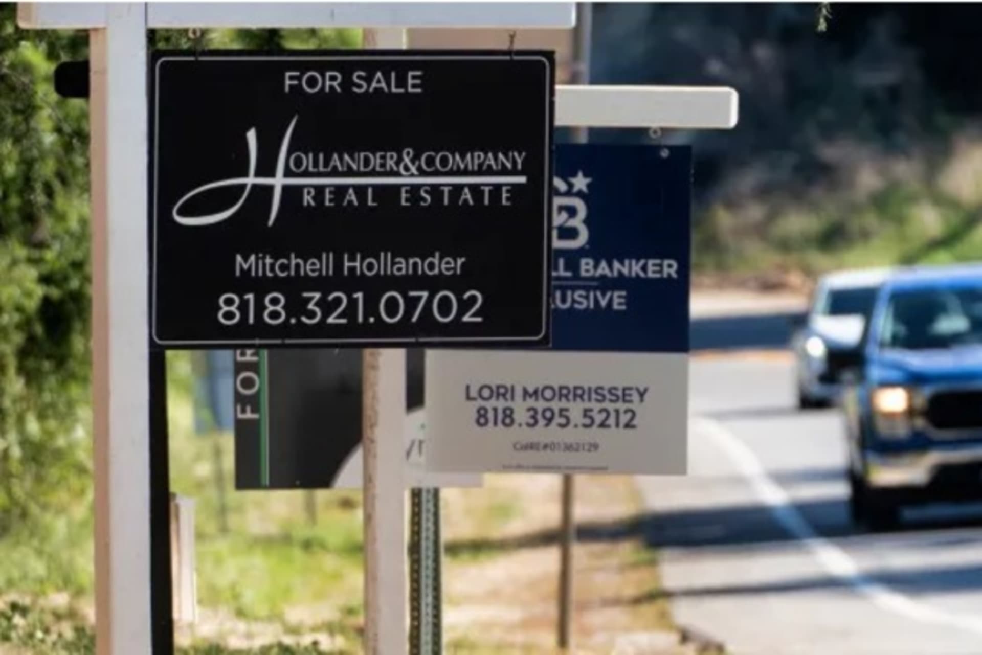 <p>Home sale signs are posted along Topanga Canyon road in Los Angeles on Oct. 19, 2023.</p>
