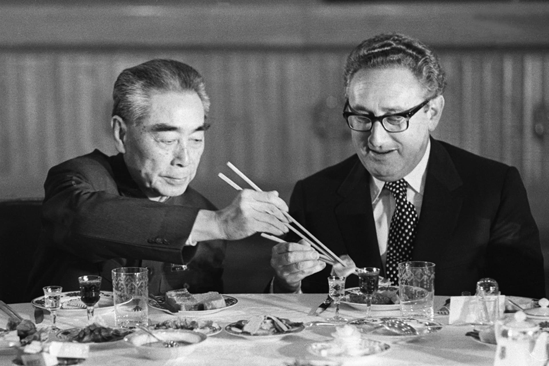 <p>U.S. Secretary of State Henry Kissinger accepts food from Chinese Premier Zhou Enlai during a state banquet in the Great Hall of the People in Beijing in 1973.</p>
