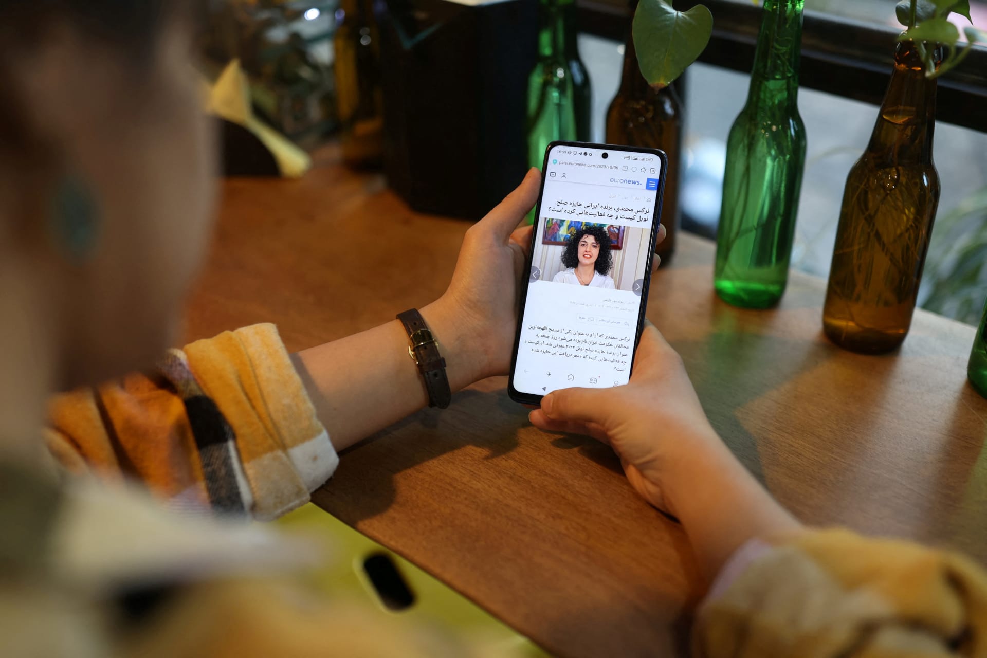 <p>An Iranian woman sees the news of Iranian activist Narges Mohammadi winning the Nobel Peace Prize on her mobile phone, in a cafe in Tehran, Iran, October 6, 2023.</p>
