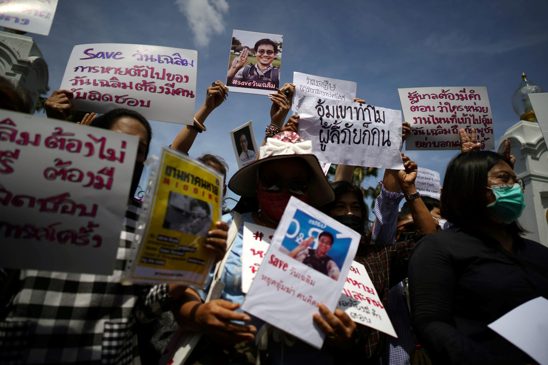 <p>Activists hold up pictures of abducted Thai activist Wanchalearm Satsaksit as people gather in support of him during a protest calling for an investigation, in front of the Government house in Bangkok, Thailand, on June 12, 2020.</p>
