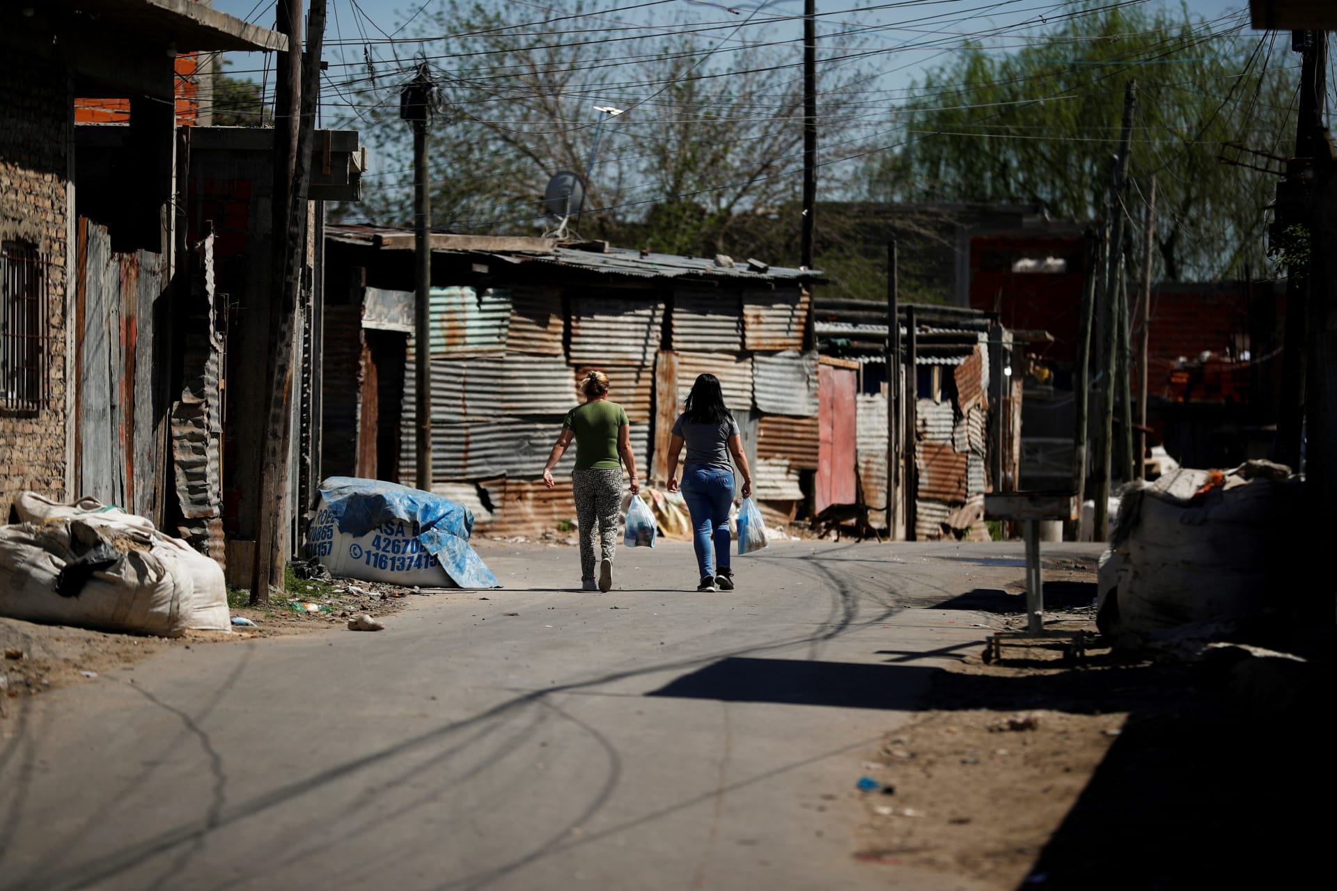 <p>Women carry shopping bags while walking in the working-class neighbourhood Villa Fiorito, in Buenos Aires, Argentina October 9, 2023.</p>
