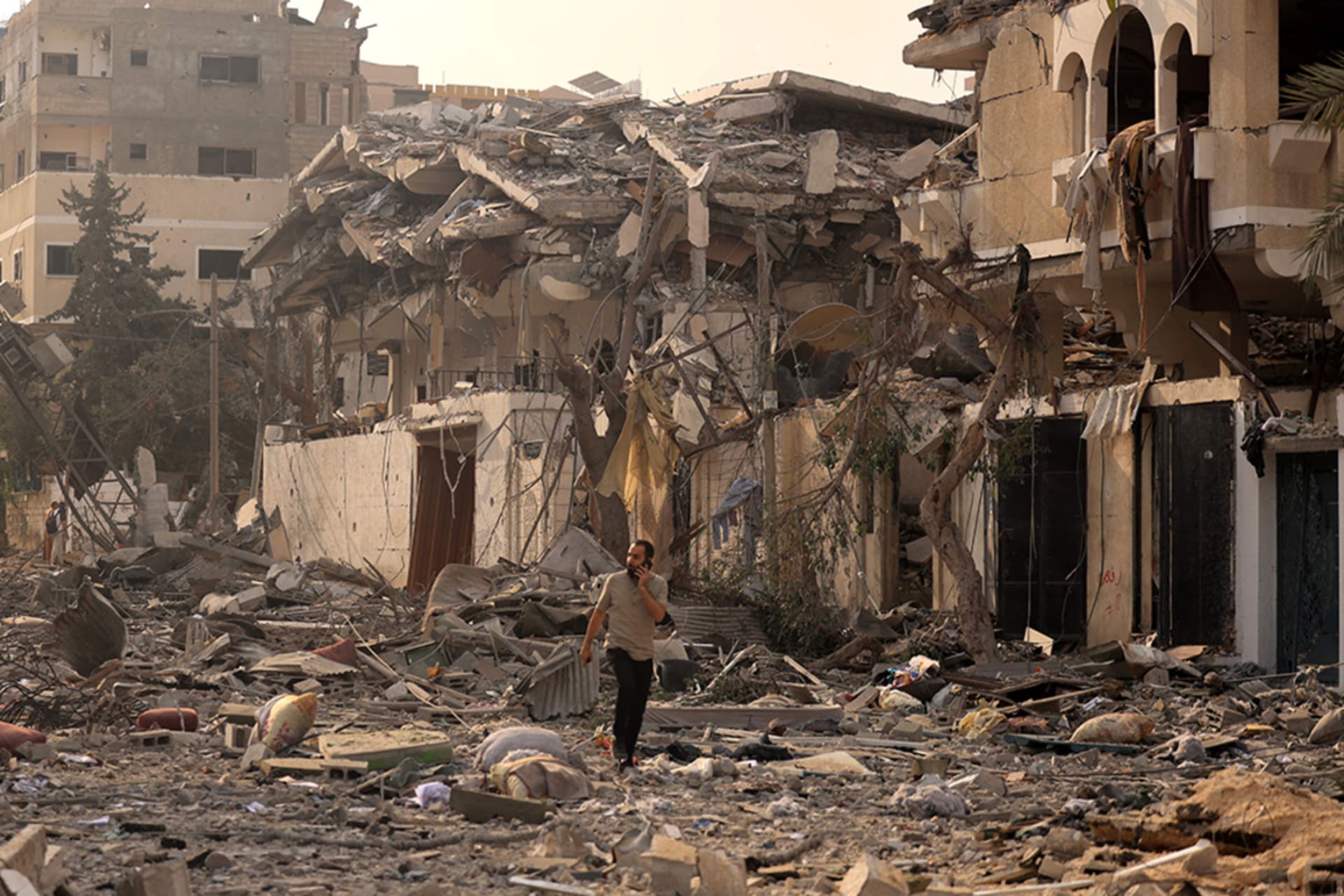 <p>A Palestinian man walks through a ravaged street in Gaza City.</p>
