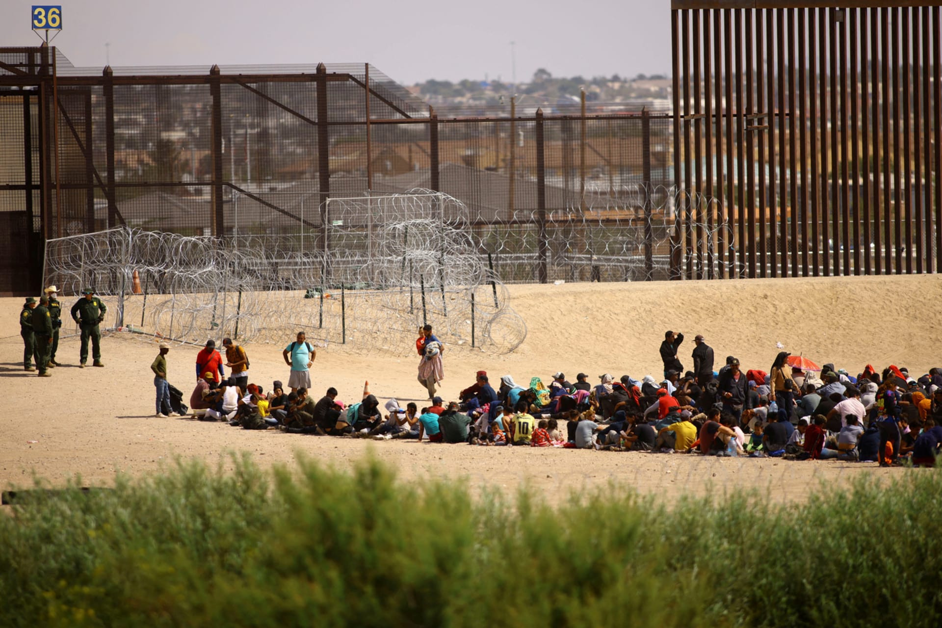 <p>Venezualan migrants gather near the U.S. border wall after crossing the Rio Bravo river, as seen from Ciudad Juarez</p>
