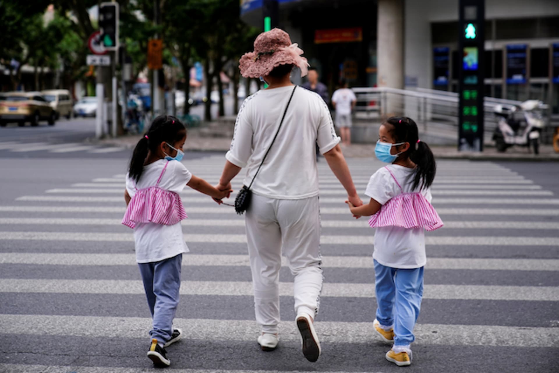 <p>A mother walks across the street with her daughters in Shanghai, China.</p>
