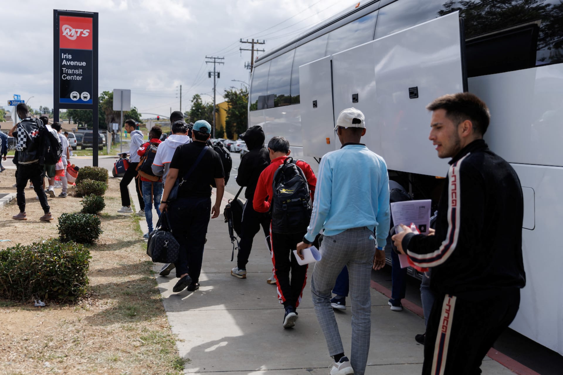 <p>After processing by U.S. Immigration, migrants are dropped off by a bus at a transit center to continue their journey in the United States from San Diego, California.</p>
