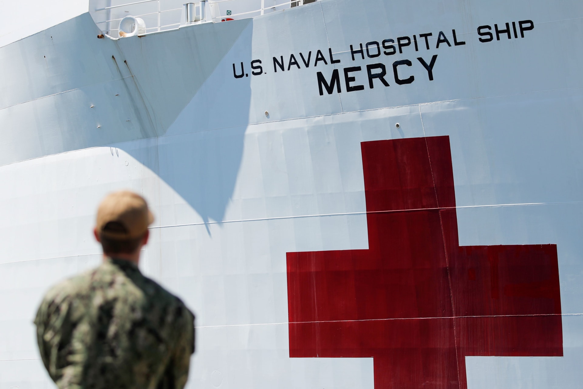 <p>A member of the army looks on as the USNS Mercy, a Navy hospital ship, departs the Naval Station San Diego to aid local medical facilities dealing with COVID-19 patients, in San Diego, California, on March 23, 2020.</p>
