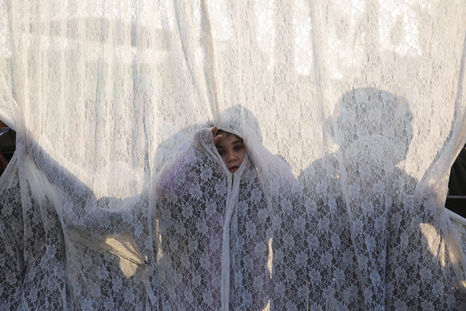 <p>A girl stands behind a curtain that separates between men and women at the gravesite of Rabbi Yisrael Abuhatzeira, a Moroccan-born sage and Kabbalist also known as the Baba Sali, during an annual pilgrimage held on the anniversary of his death in the sout</p>
