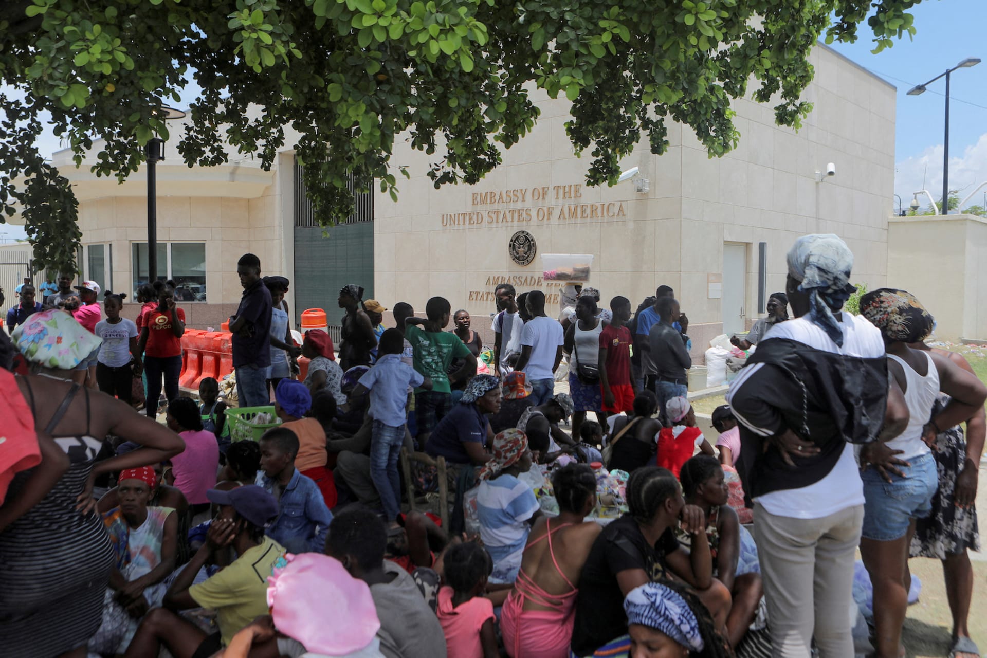 <p>People escaping the threat of armed gangs rest under a tree as they camp in front of the U.S. Embassy, in Port-au-Prince, Haiti, July 25, 2023.</p>
