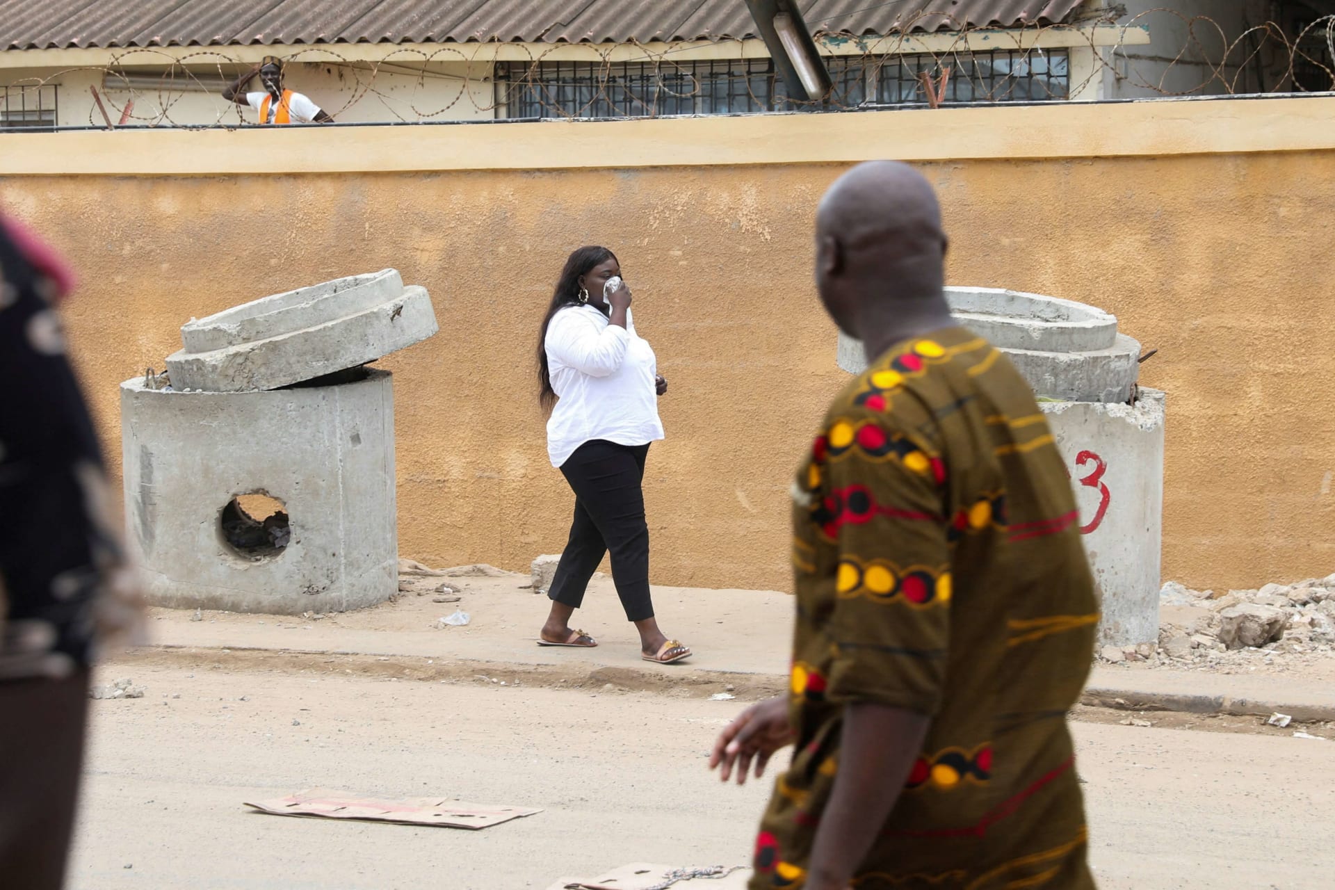 <p>A woman covers her face after gendarmes shot tear gas to disperse a crowd of protestors after opposition leader Ousmane Sonko was detained, in Dakar, Senegal on July 31, 2023.</p>
