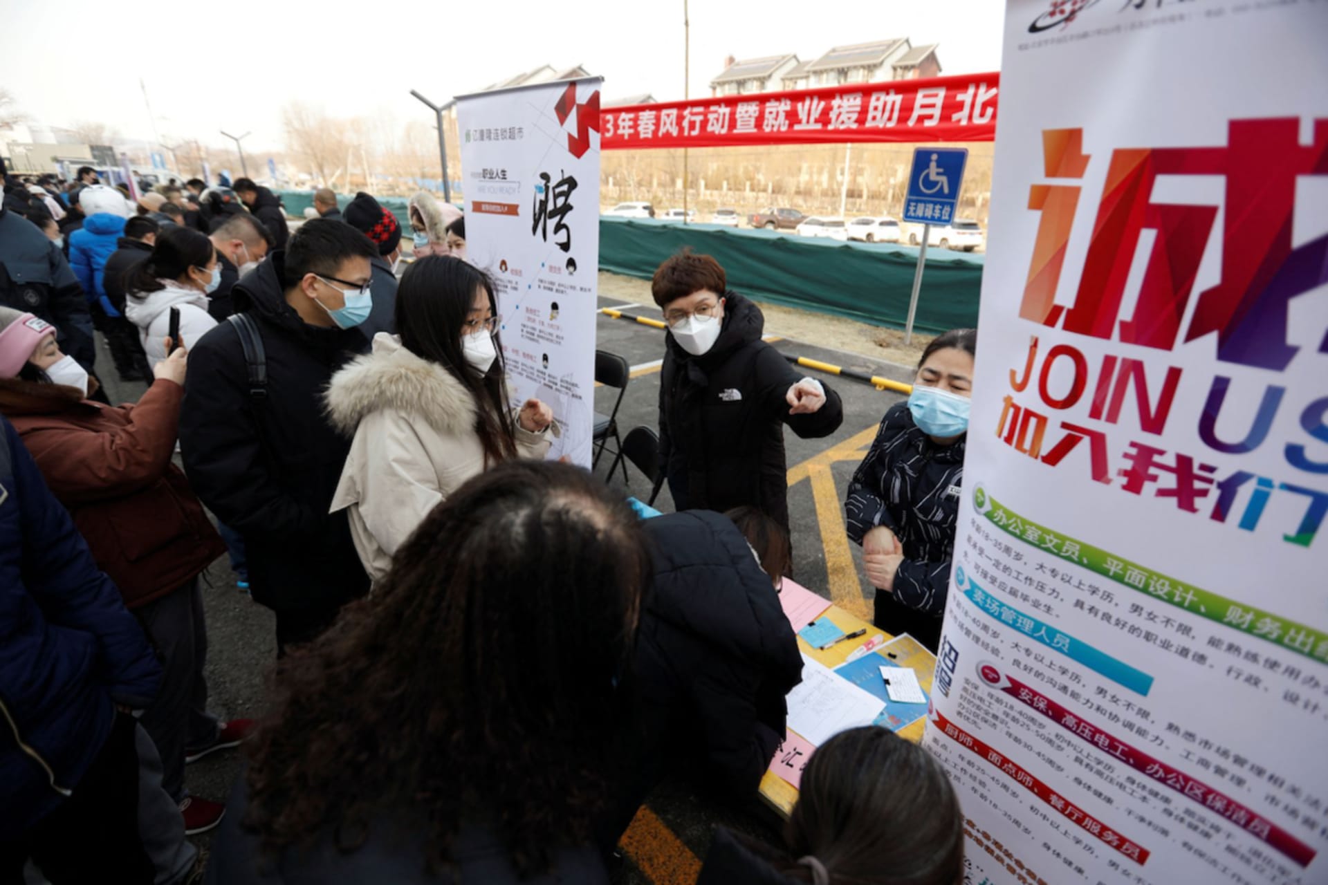 <p>Job seekers crowd around a booth at a job fair in Beijing, China.</p>
