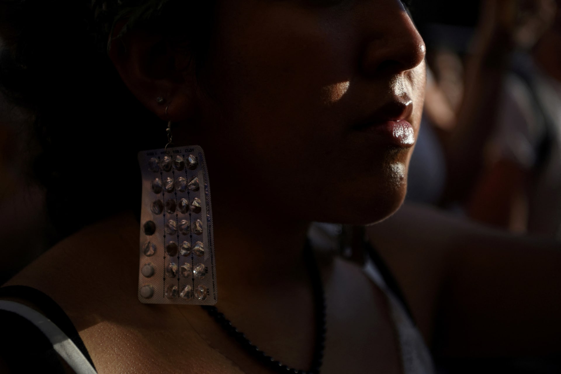 <p>An abortion rights protester wears earrings made of birth control packets as protesters gather outside of the federal courthouse in downtown Houston, Texas, after the United States Supreme Court ruled in the Dobbs v Women’s Health Organization abortion ca</p>
