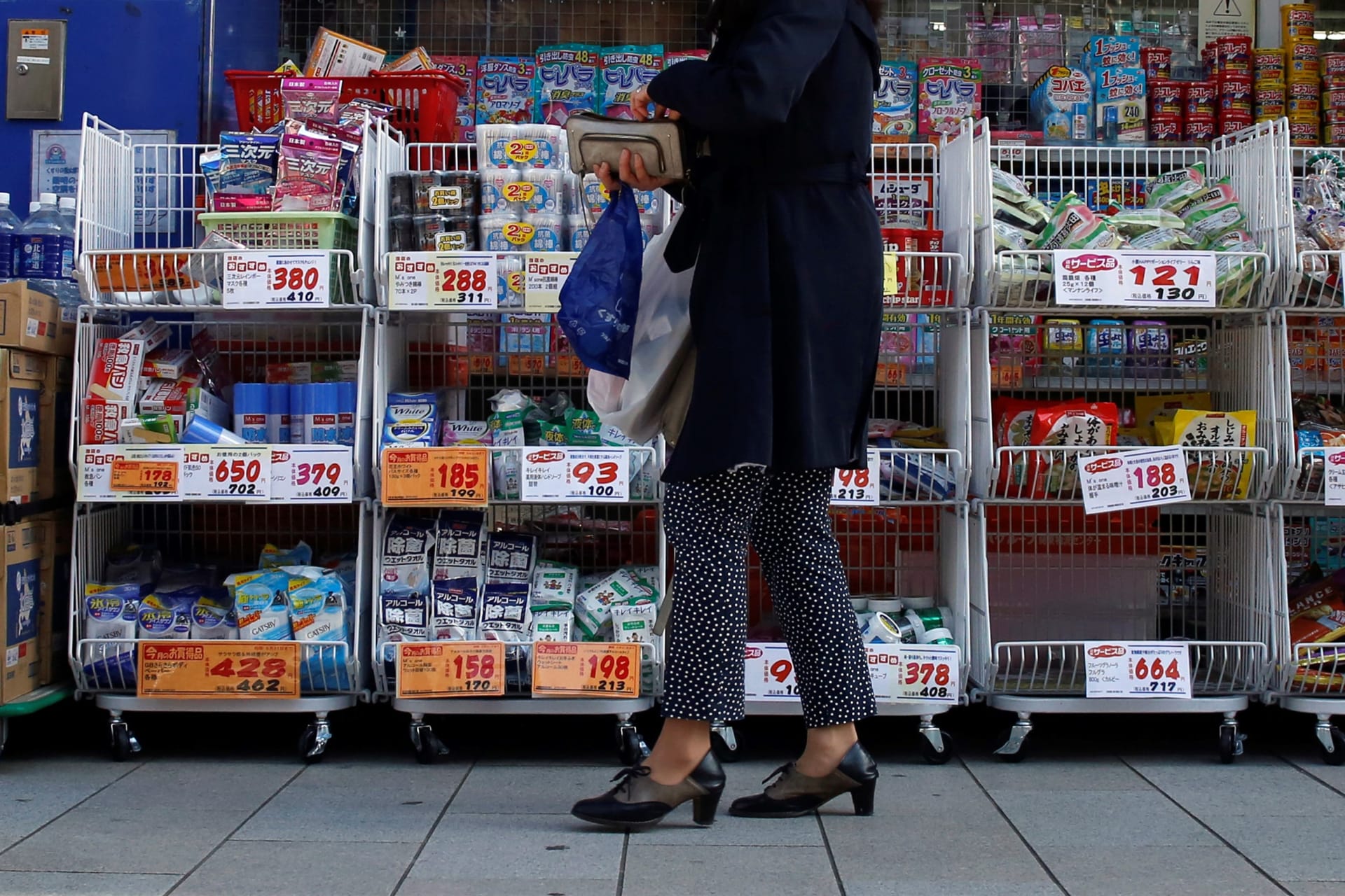 <p>A woman stands outside a pharmacy in Tokyo April 7, 2014</p>
