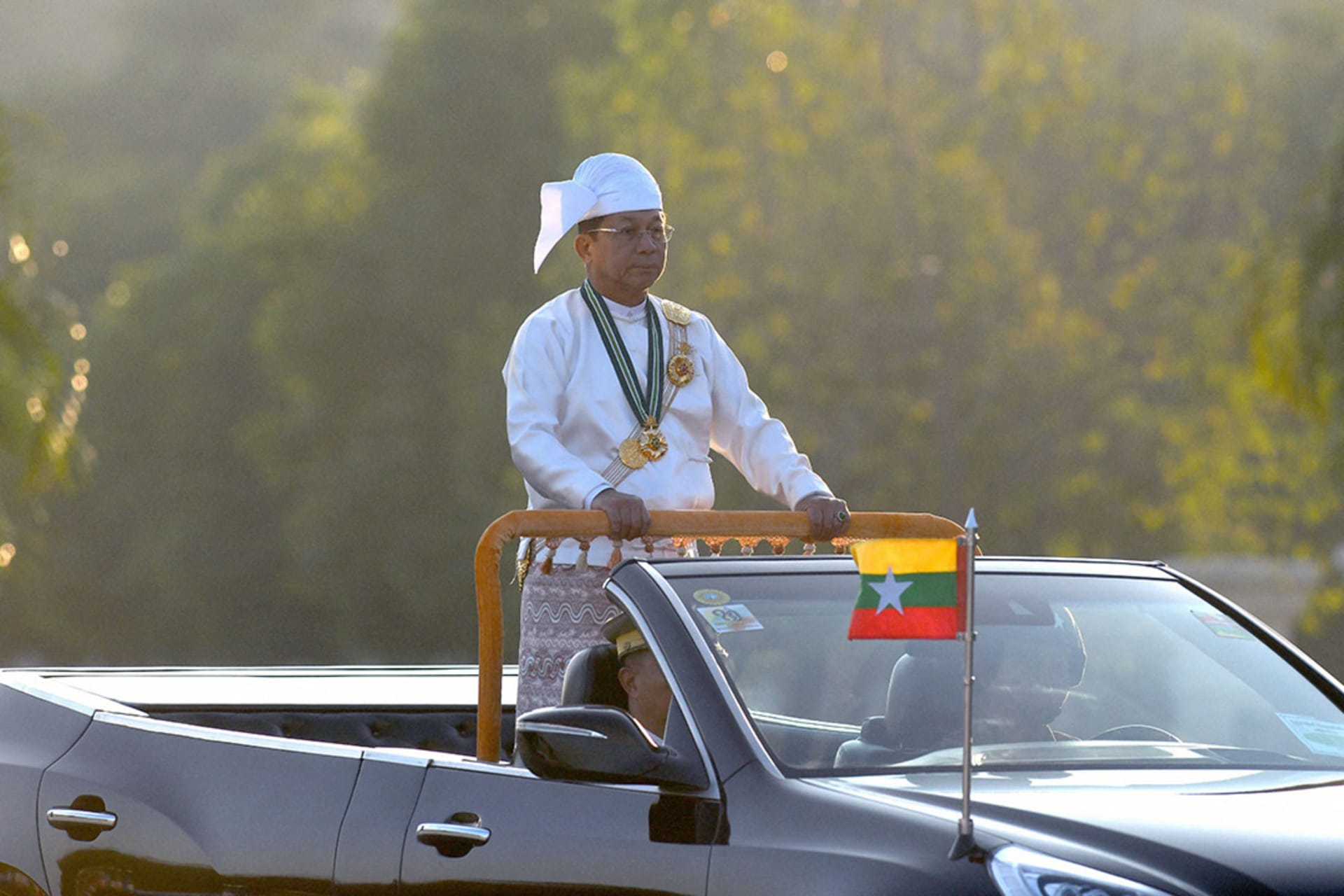 <p>Myanmar’s military chief Min Aung Hlaing stands in a car as he oversees a military display at a parade ground to mark the country’s Independence Day in Naypyidaw on January 4, 2023.</p>
