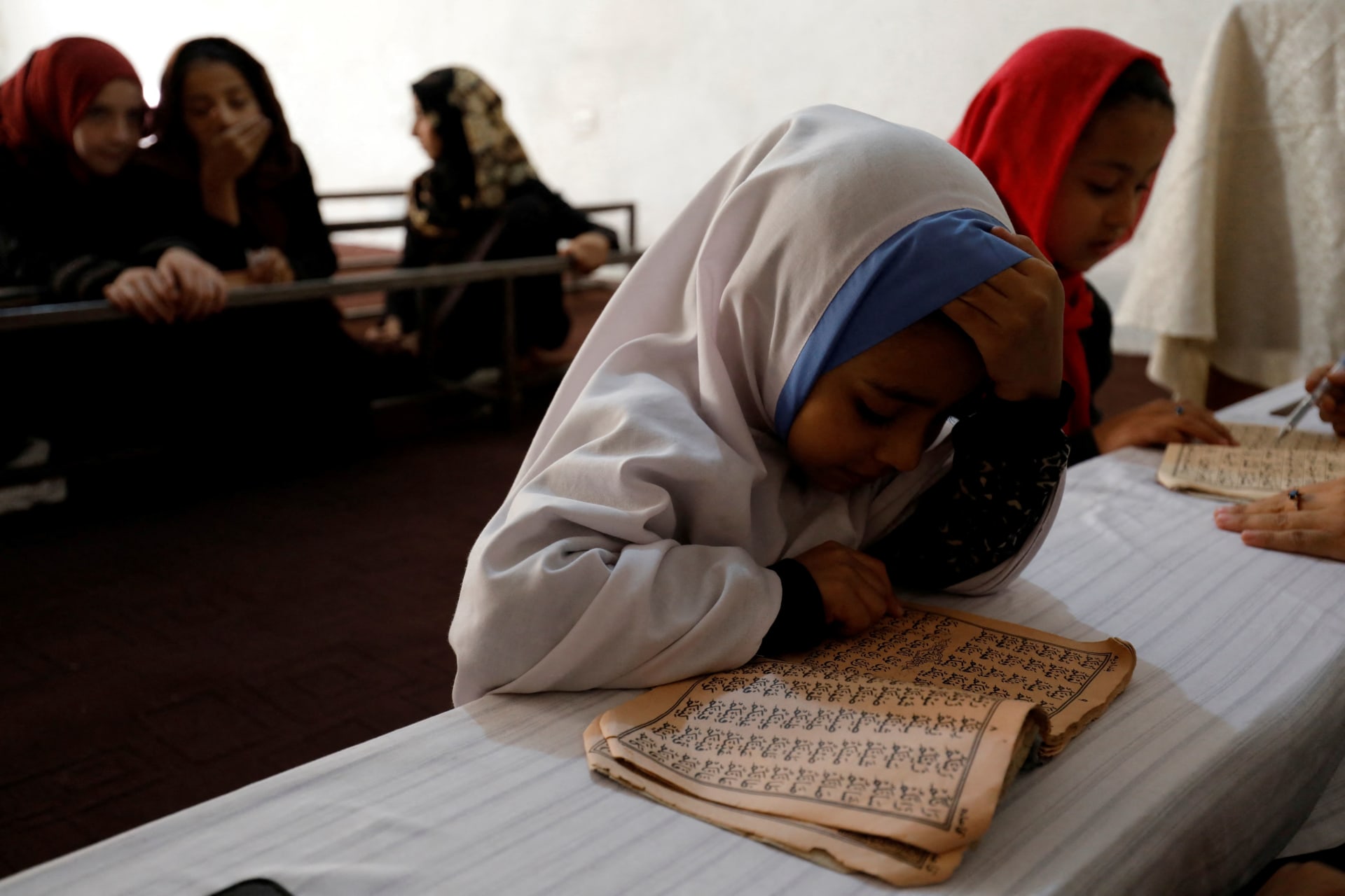 <p>An Afghan girl reads the Koran in a madrasa or religious school in Kabul, Afghanistan, October 8, 2022.</p>
