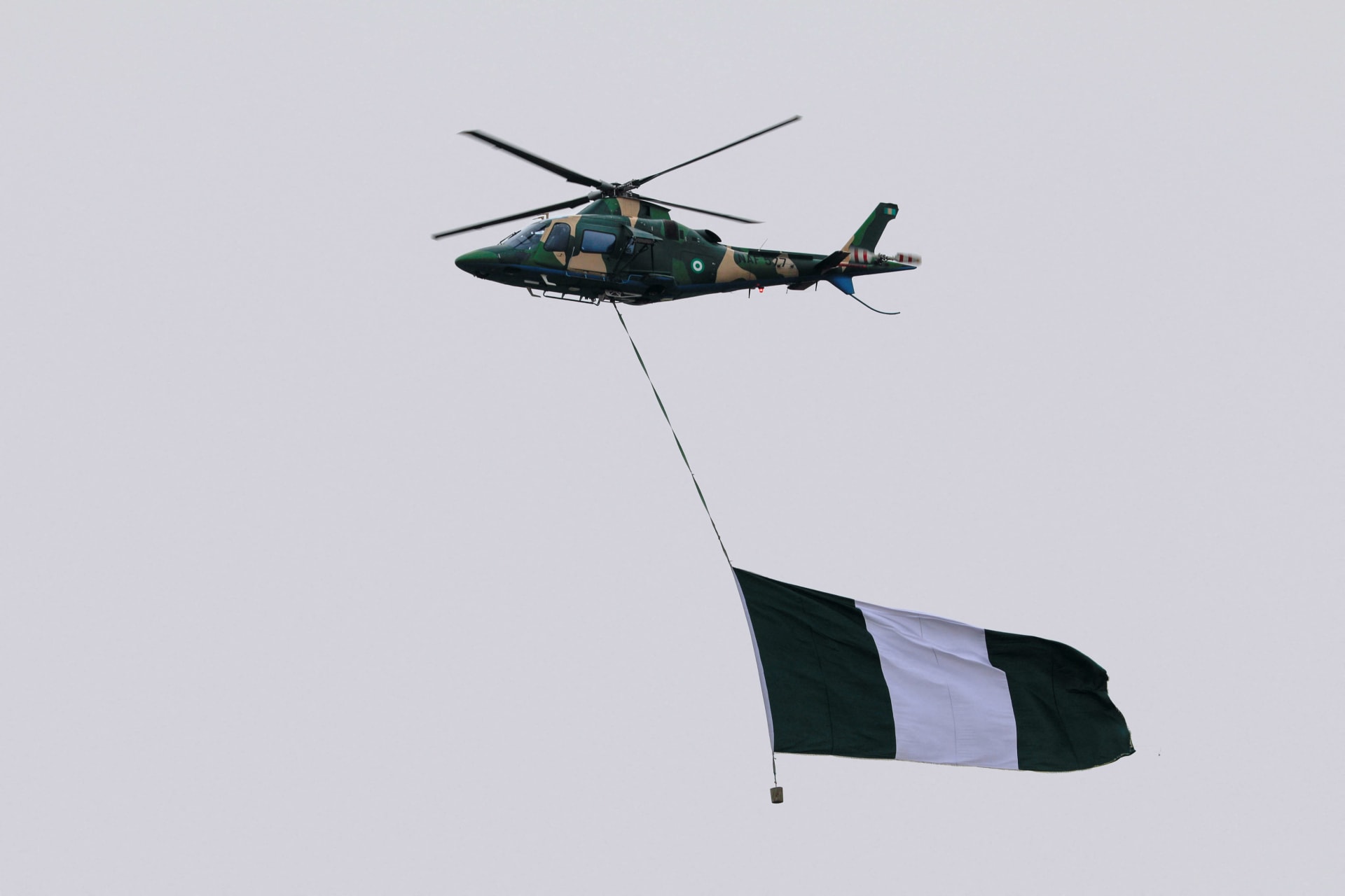 <p>A Nigerian military helicopter carries a Nigerian flag during the swearing-in ceremony of Nigeria’s President Bola Tinubu in Abuja, Nigeria on May 29, 2023. </p>

