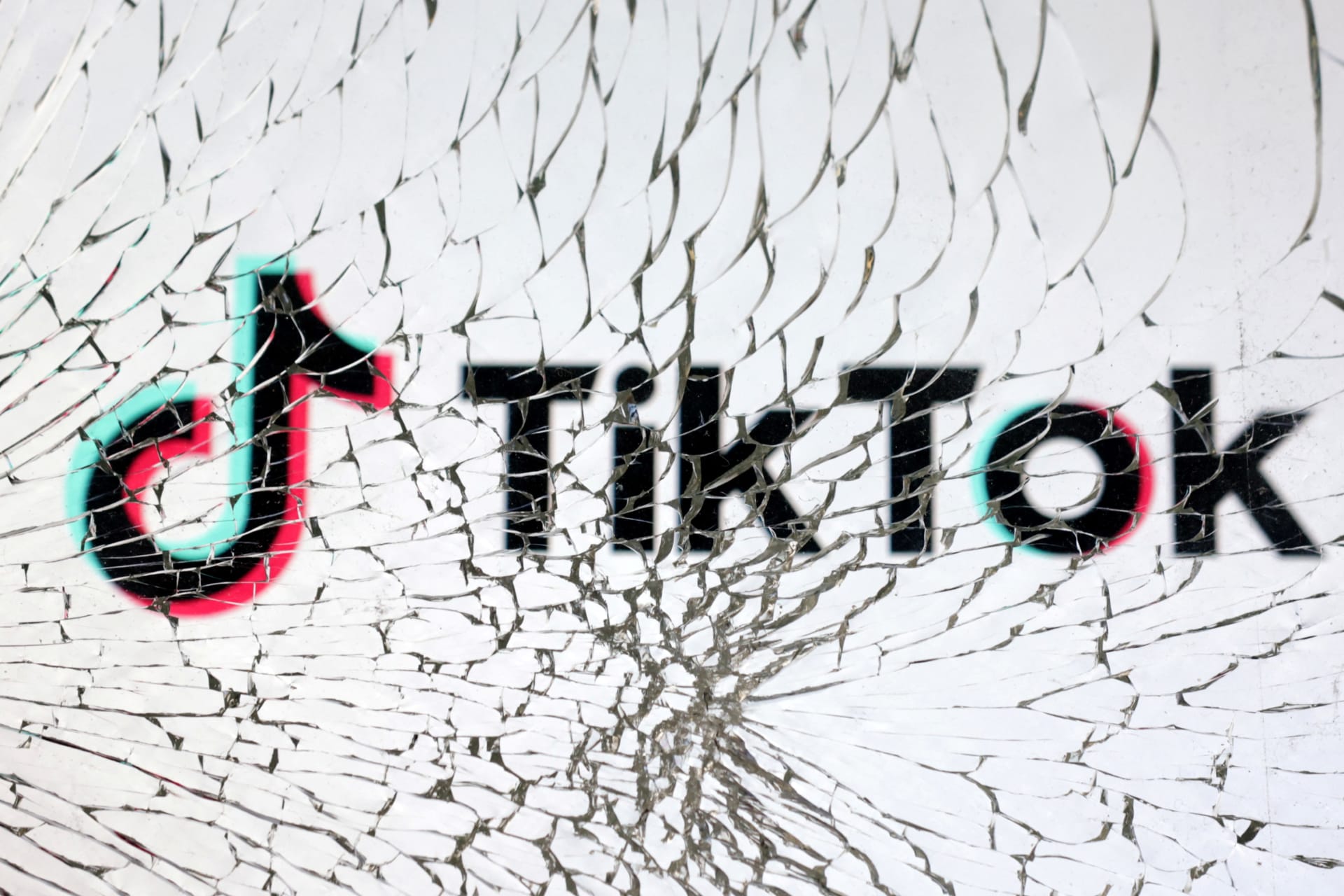 <p>TikTok’s logo is seen through broken glass.</p>
