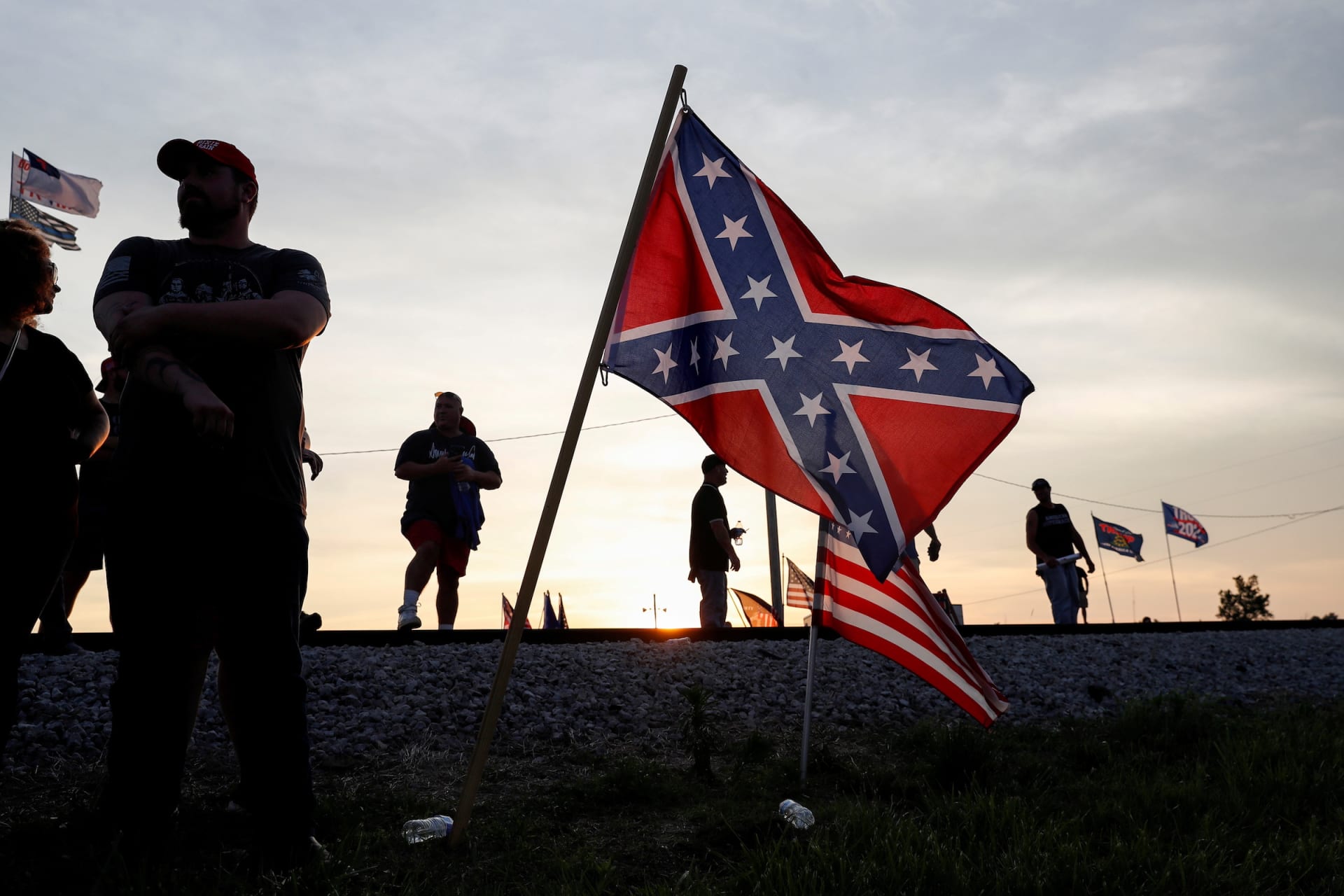 <p>Supporters of former U.S. President Donald Trump stand near Confederate and U.S. flags in Wellington, Ohio on June 26, 2021.</p>
