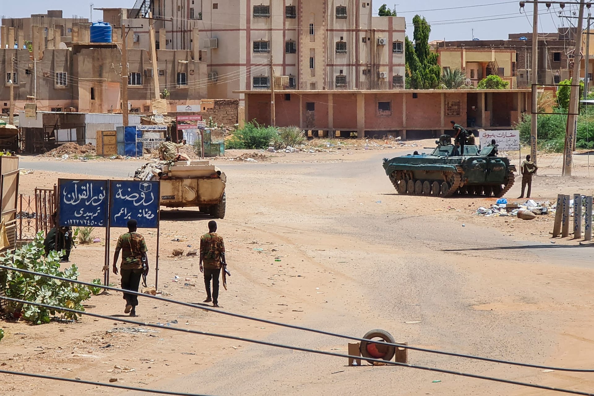 <p>Soldiers with the Sudanese Armed Forces walk near armored vehicles amid fighting with the Rapid Support Forces in Khartoum, Sudan on May 6, 2023.</p>
