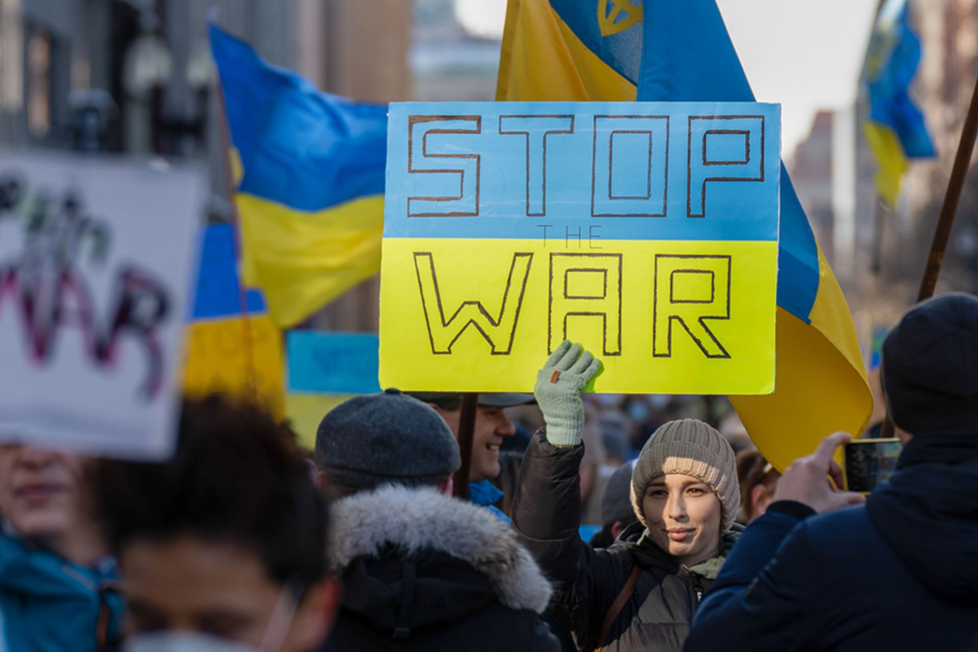 <p>A demonstrator holds a sign during a peaceful stand for Ukraine rally in Boston in February 2022.</p>
