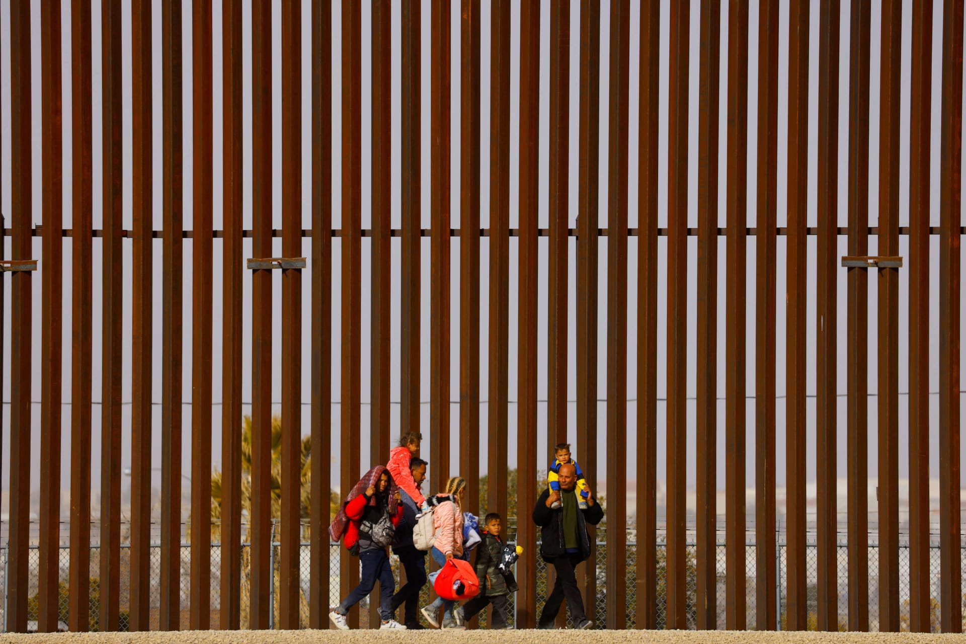 <p>The Hernandez family, Venezuelan migrants seeking asylum in the U.S. who were not received for the appointment they got using the U.S. Customs and Border Protection (CBP) CBP One application, walk next to the border wall after crossing the Rio Bravo river</p>
