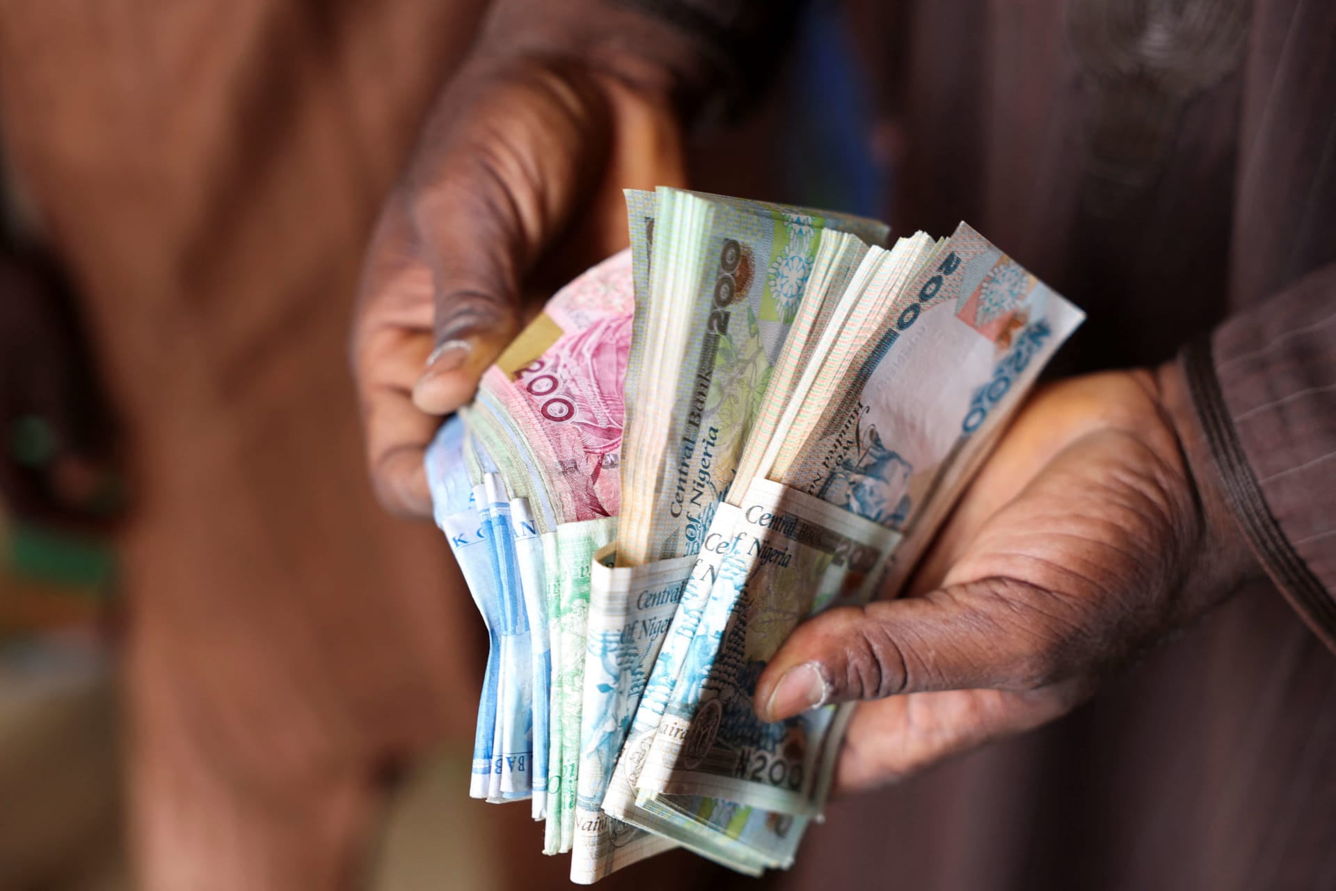 <p>A man counts Nigerian naira notes in a market place as people struggle with the economic hardship and cashflow problems ahead of Nigeria’s Presidential elections, in Yola, Nigeria on February 22, 2023.</p>

