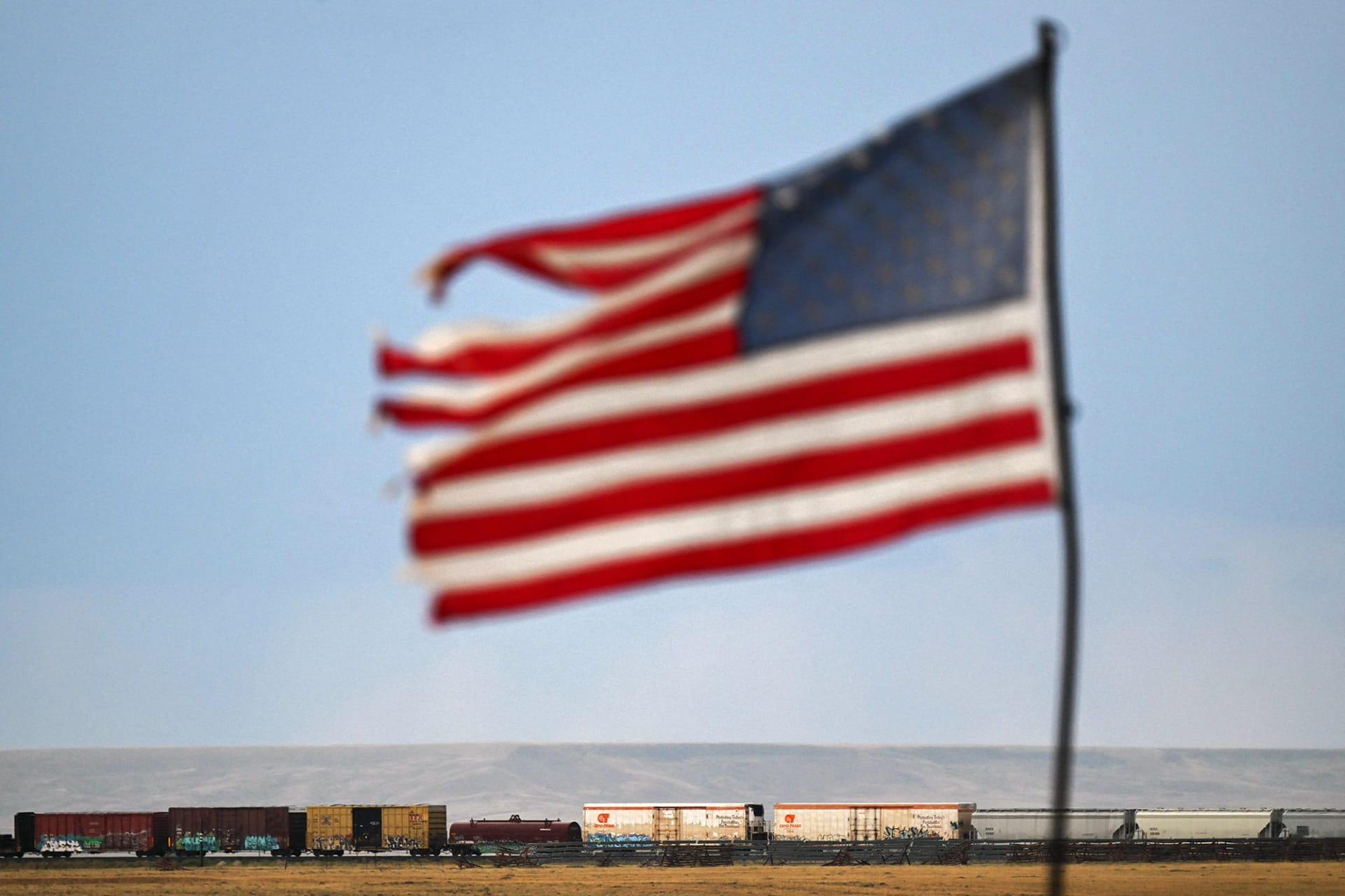 <p>A U.S. flag waves above a freight train in Bosler, Wyoming.</p>
