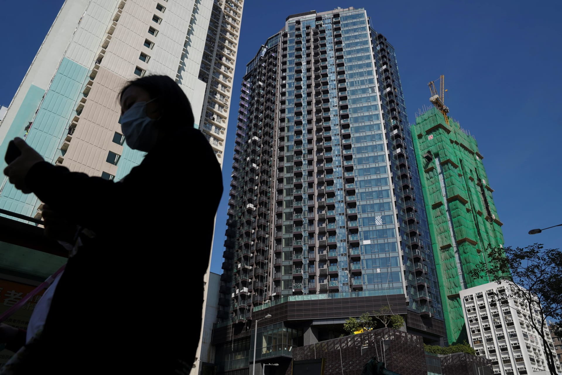<p>A pedestrian walks past an Evergrande residential development in Hong Kong, China, November 27, 2021. (Lam Yik/REUTERS)</p>
