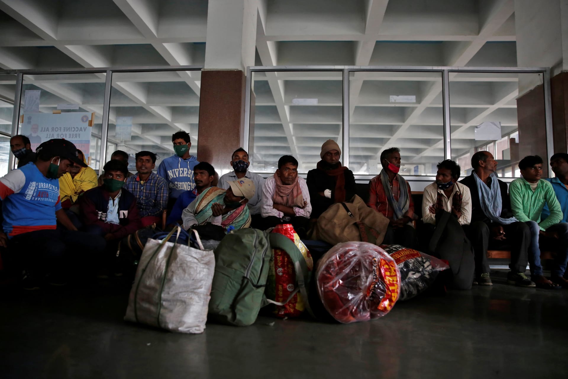 <p>Indian migrant workers wait inside a railway station to board trains to their home states</p>
