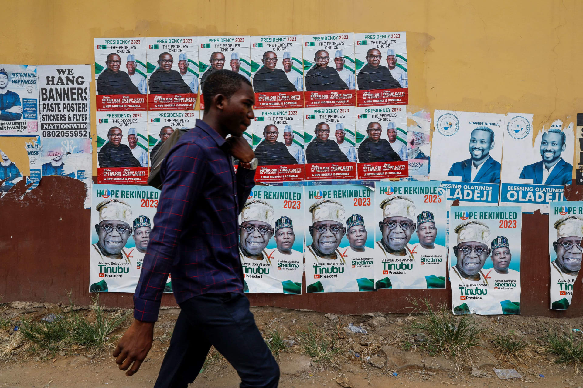 <p>A man walks past electoral campaign posters, ahead of Nigeria’s Presidential elections, in Lagos, Nigeria on January 31, 2023.</p>

