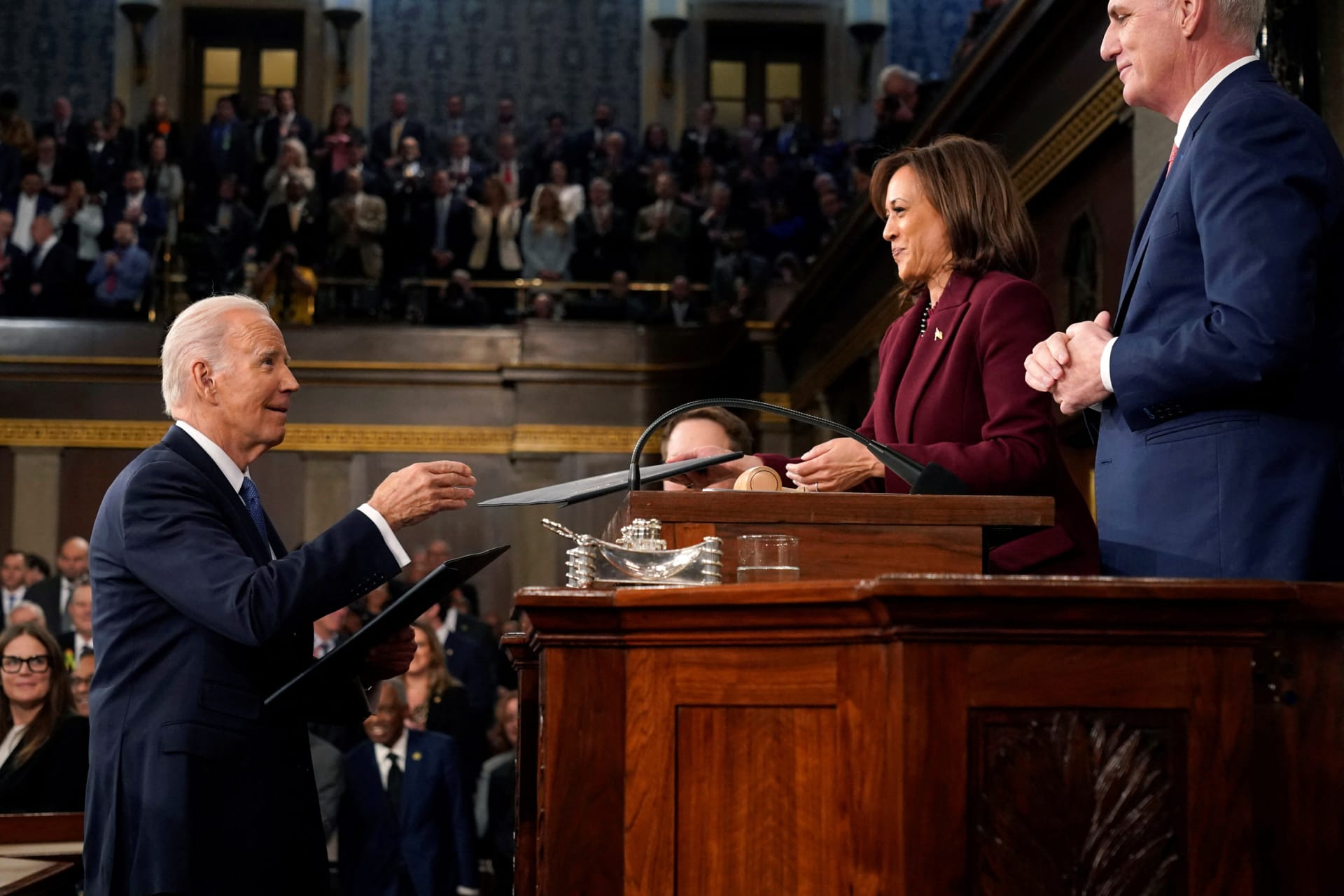 <p>U.S. President Joe Biden hands over copies of his State of the Union address to a joint session of Congress to Vice President Kamala Harris and Speaker Kevin McCarthy</p>
