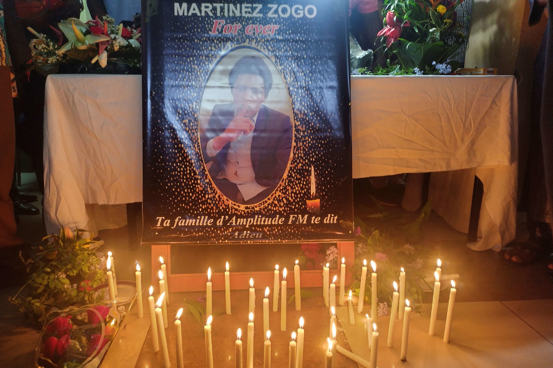 <p>Candles are kept in front of Cameroon journalist Martinez Zogo’s photo as fellow journalists pay their last respect to him after he was found dead after abduction, in Yaounde, Cameroon on January 23, 2023.</p>
