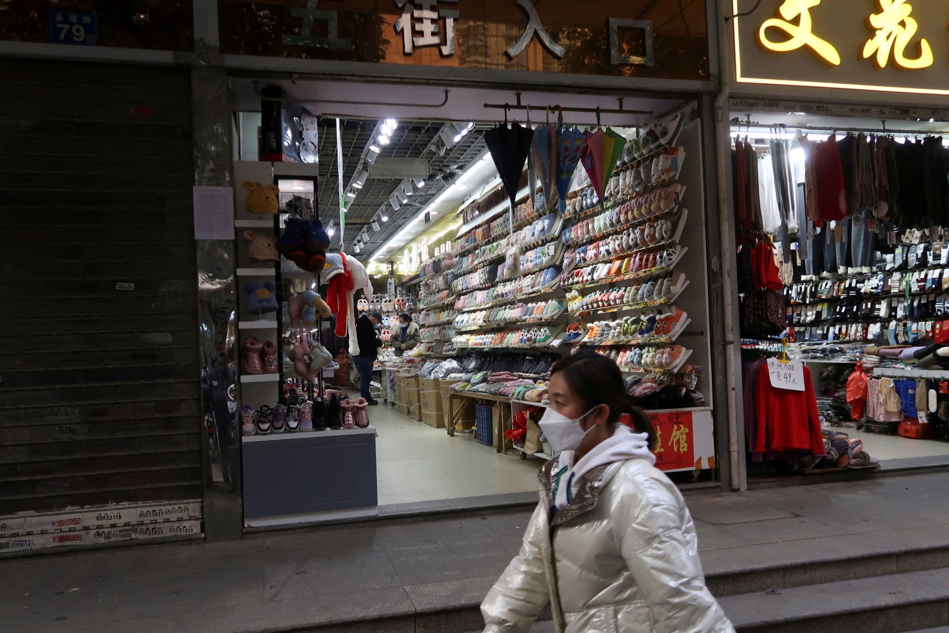 <p>A person walks past shops, after the government eased curbs on the coronavirus disease (COVID-19) control, in Wuhan, Hubei province, China December 10, 2022. REUTERS/Martin Pollard</p>
