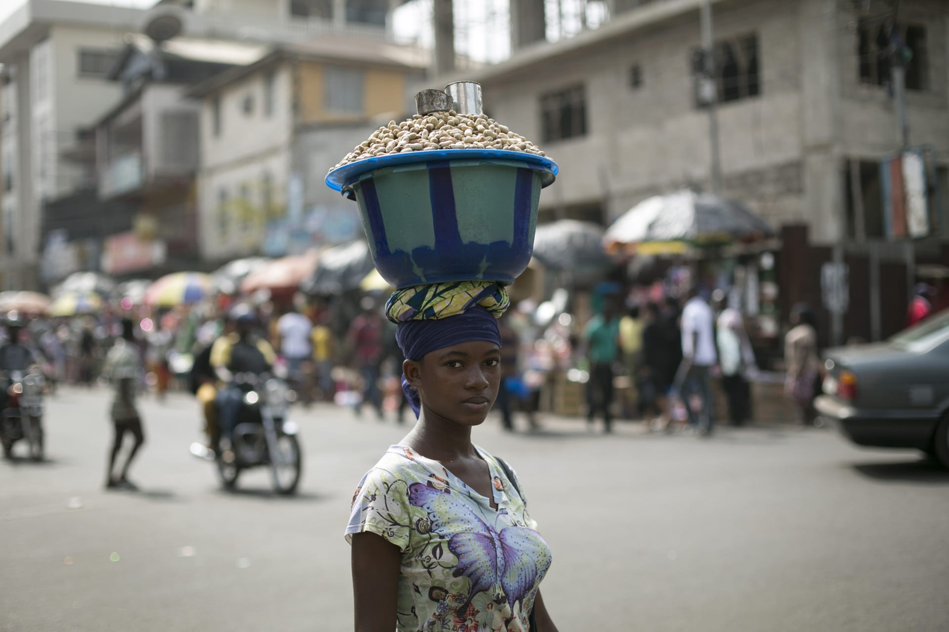 <p>Sierra Leonen woman carries a pot of peanuts on her head in Freetown.</p>
