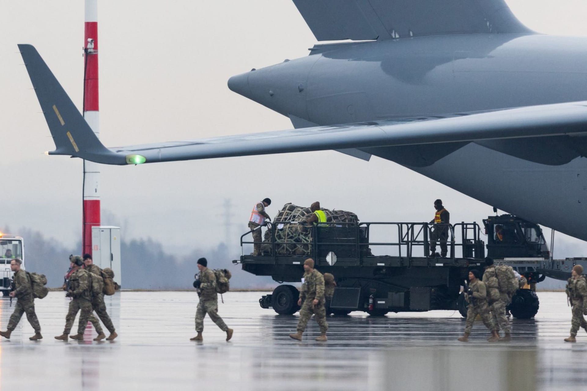 <p>U.S. soldiers unload equipment from a plane at Rzeszów Airport in Poland in February 2022.</p>
