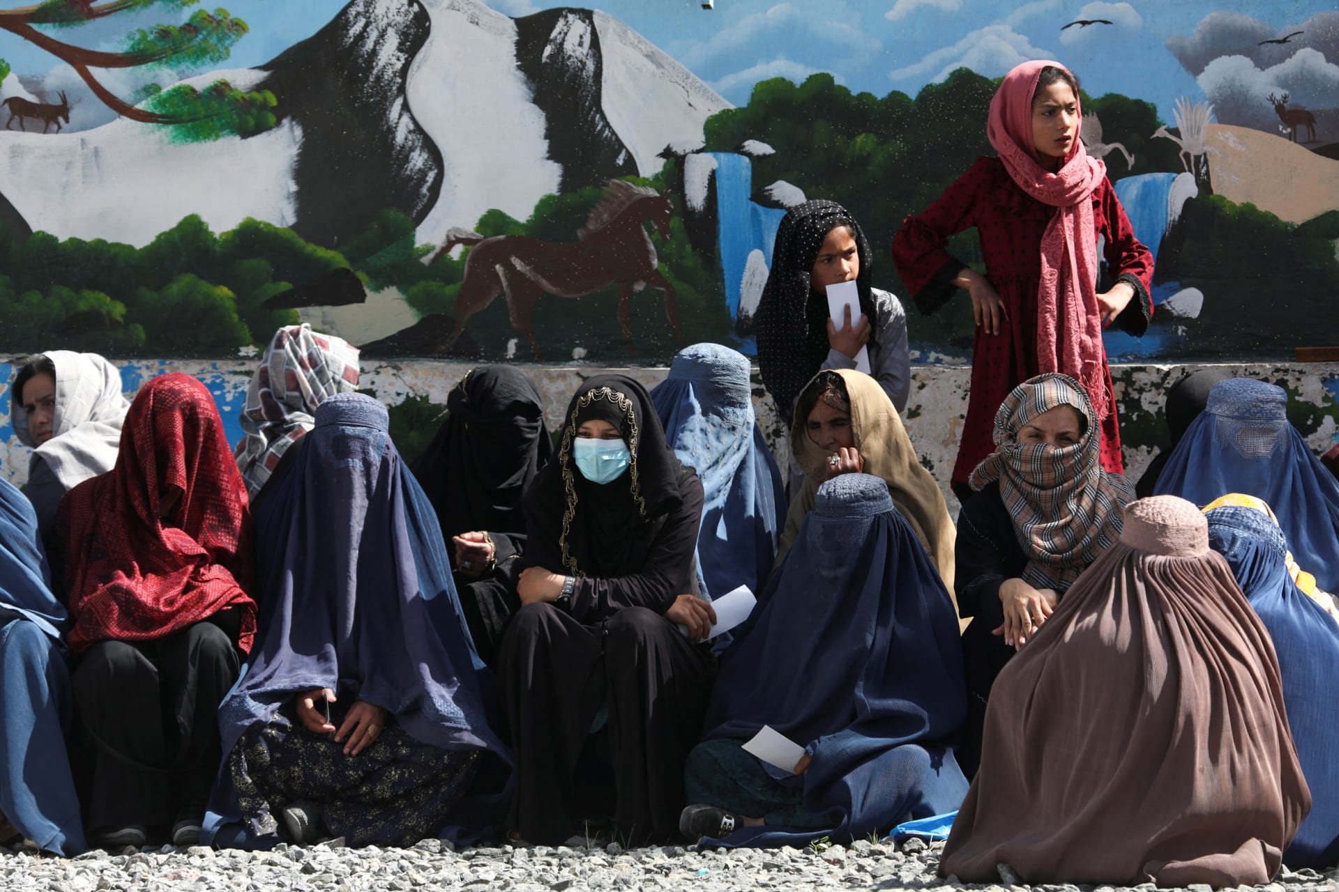 <p>Afghan women wait to receive a food package at a distribution center in Kabul.</p>
