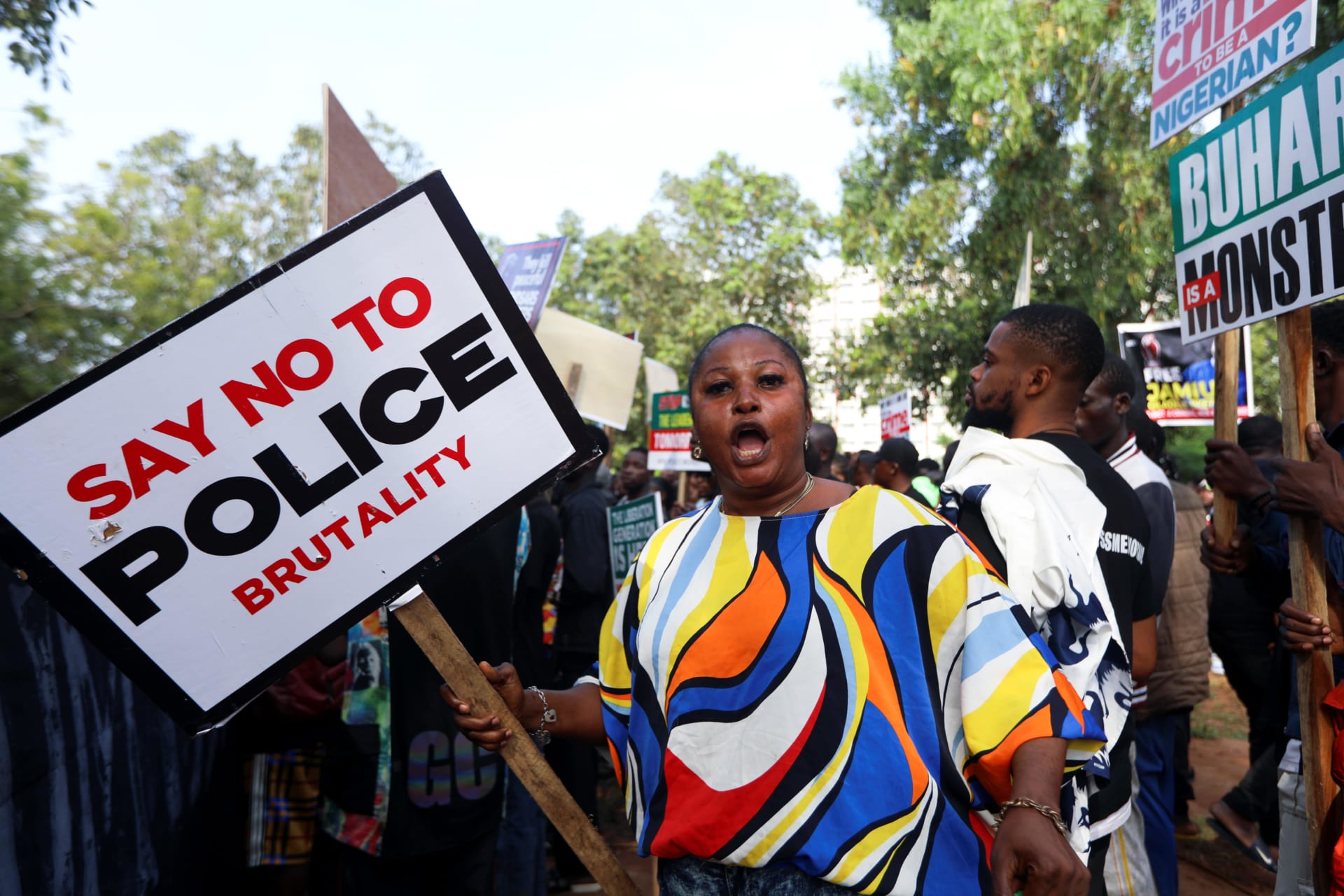<p>A protestor reacts as she holds a placard as Nigerians mark the one-year anniversary of the #EndSARS anti-police brutality protest in Abuja, Nigeria on October 20, 2021.</p>
