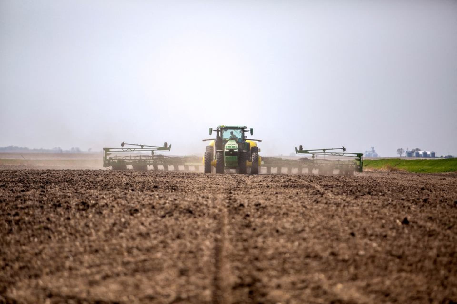 <p>A farmer drives a tractor in Iowa in April 2021.</p>
