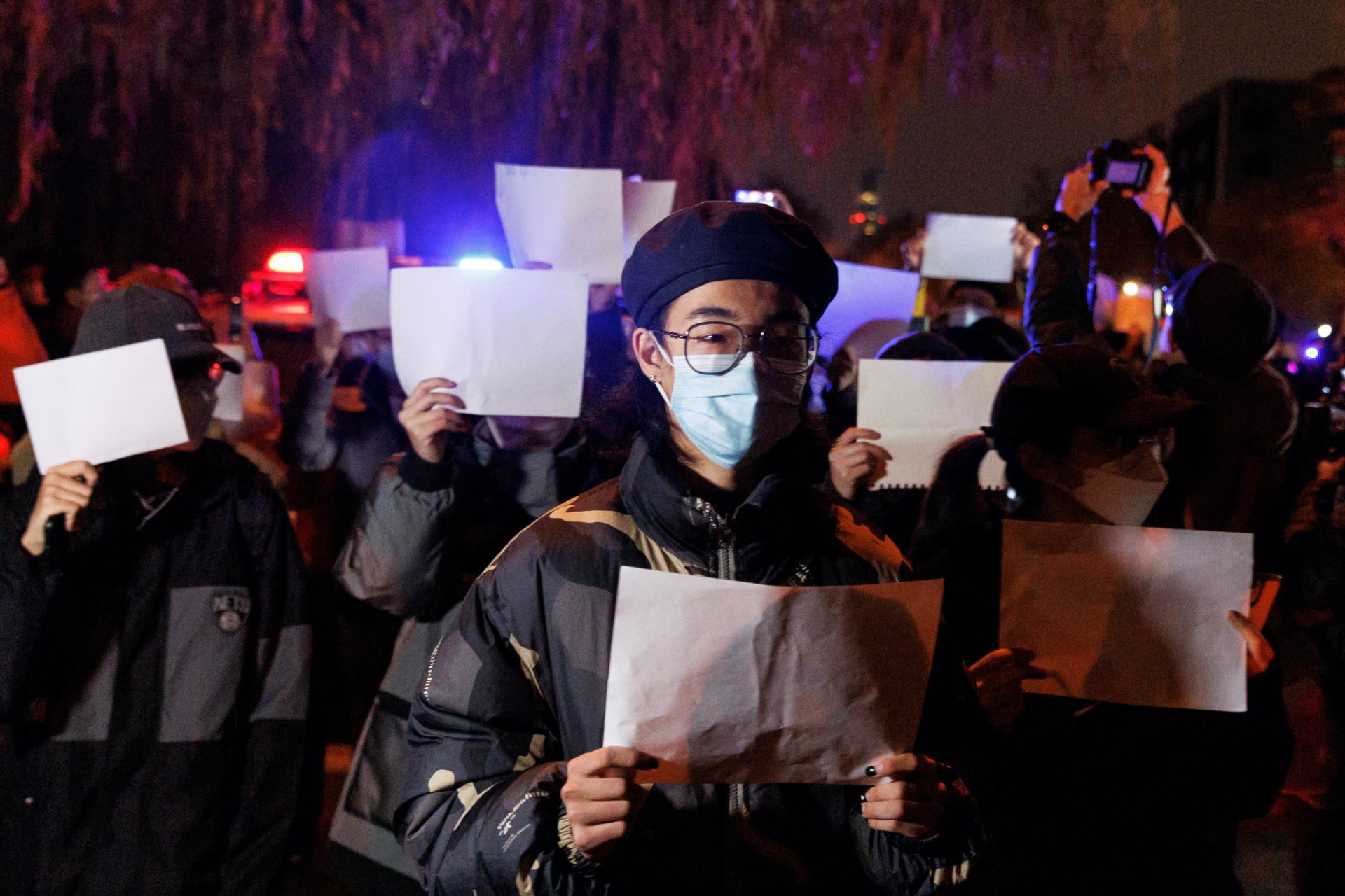 <p>People hold white sheets of paper in protest of coronavirus disease (COVID-19) restrictions, after a vigil for the victims of a fire in Urumqi, as outbreaks of the coronavirus disease continue in Beijing, China, November 27, 2022. </p>
