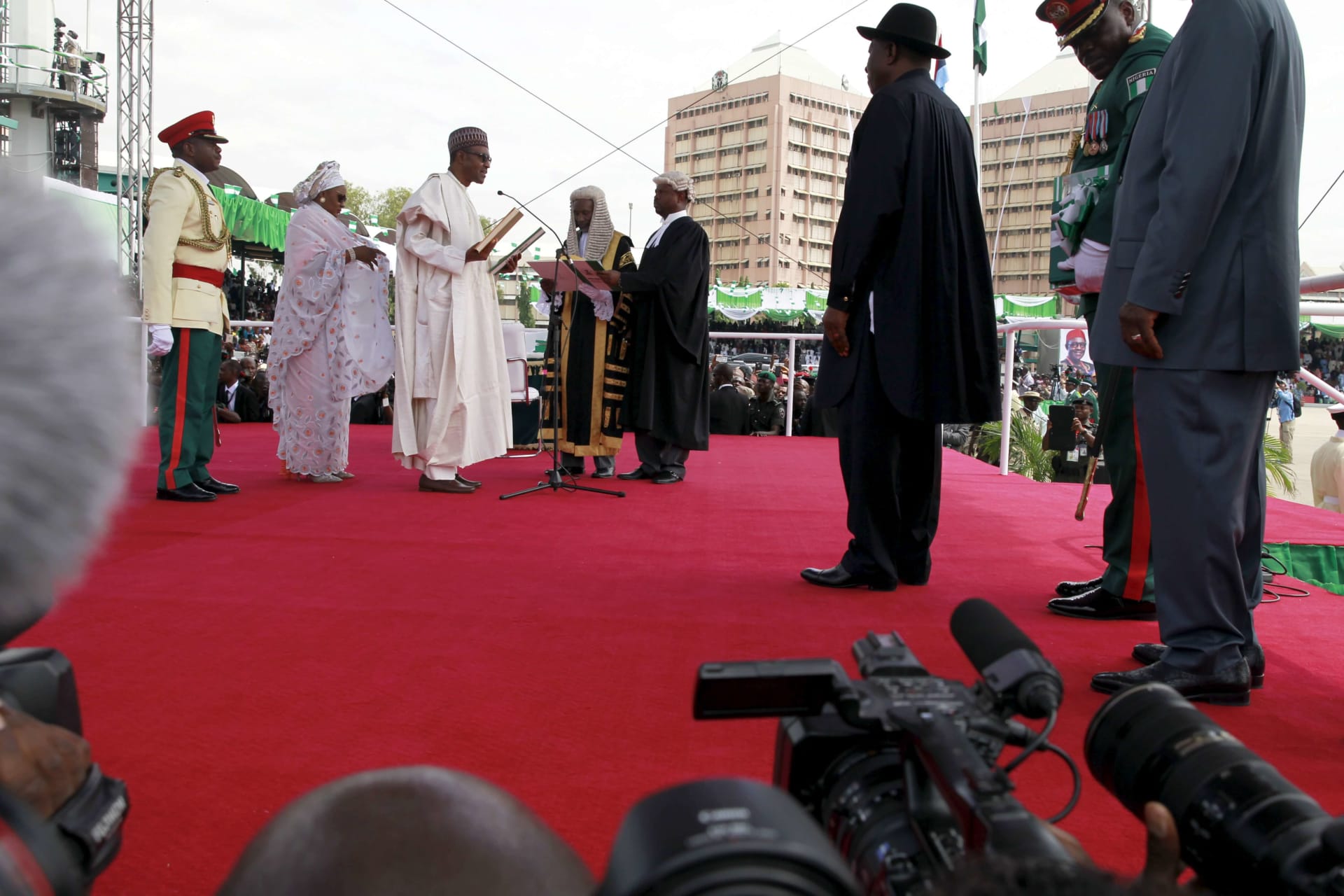 <p>Nigeria’s then incoming President Muhmmadu Buhari takes his oath of office as outgoing President Goodluck Jonathan looks on at Eagle Square in Abuja, Nigeria on May 29, 2015.</p>
