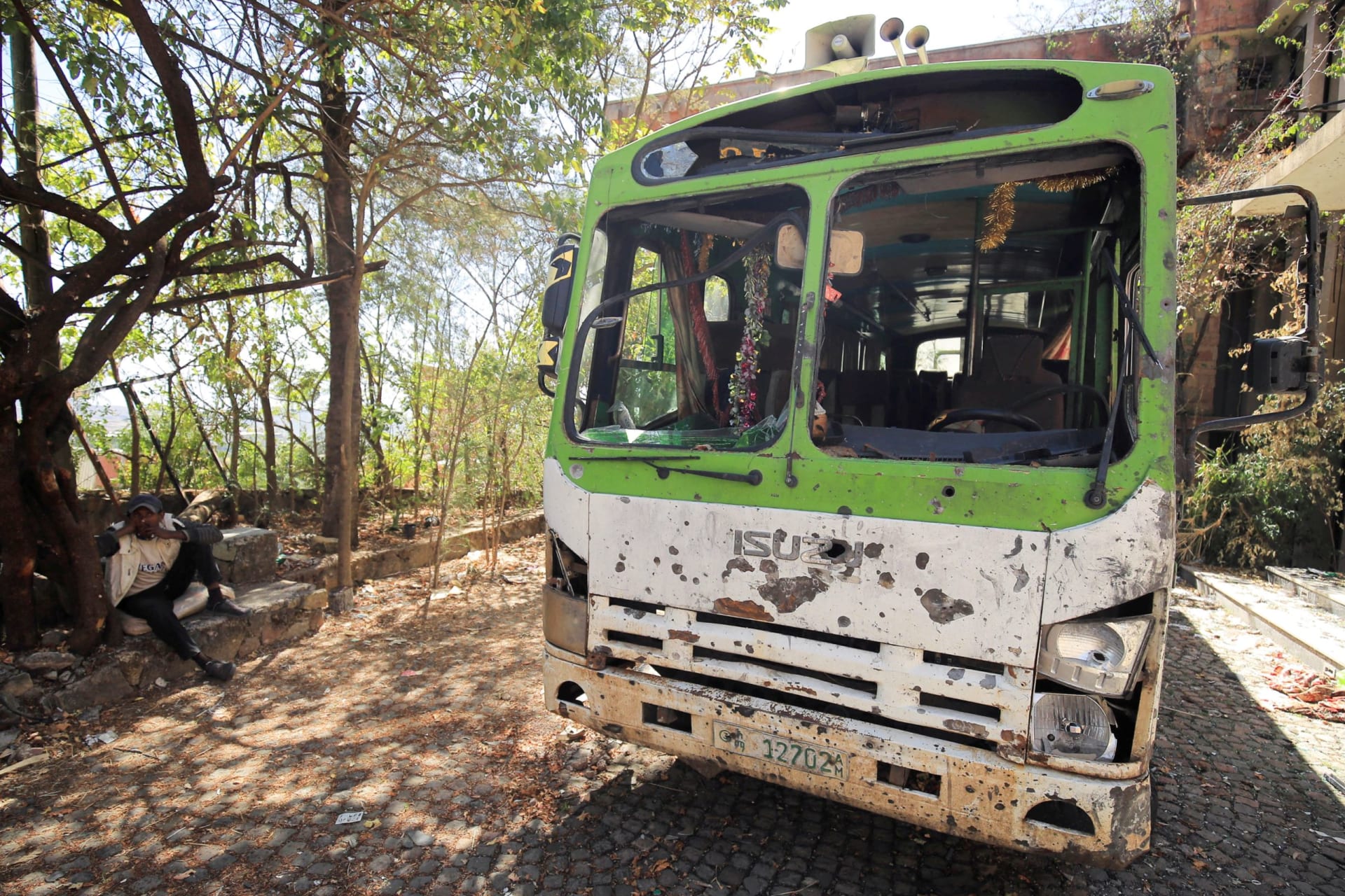 <p>A man sits beside a bus destroyed during the fighting between Ethiopia’s National Defense Force (ENDF) and the Tigray People’s Liberation Front (TPLF) forces in Lalibela town of the Amhara Region, Ethiopia, on January 25, 2022.</p>
