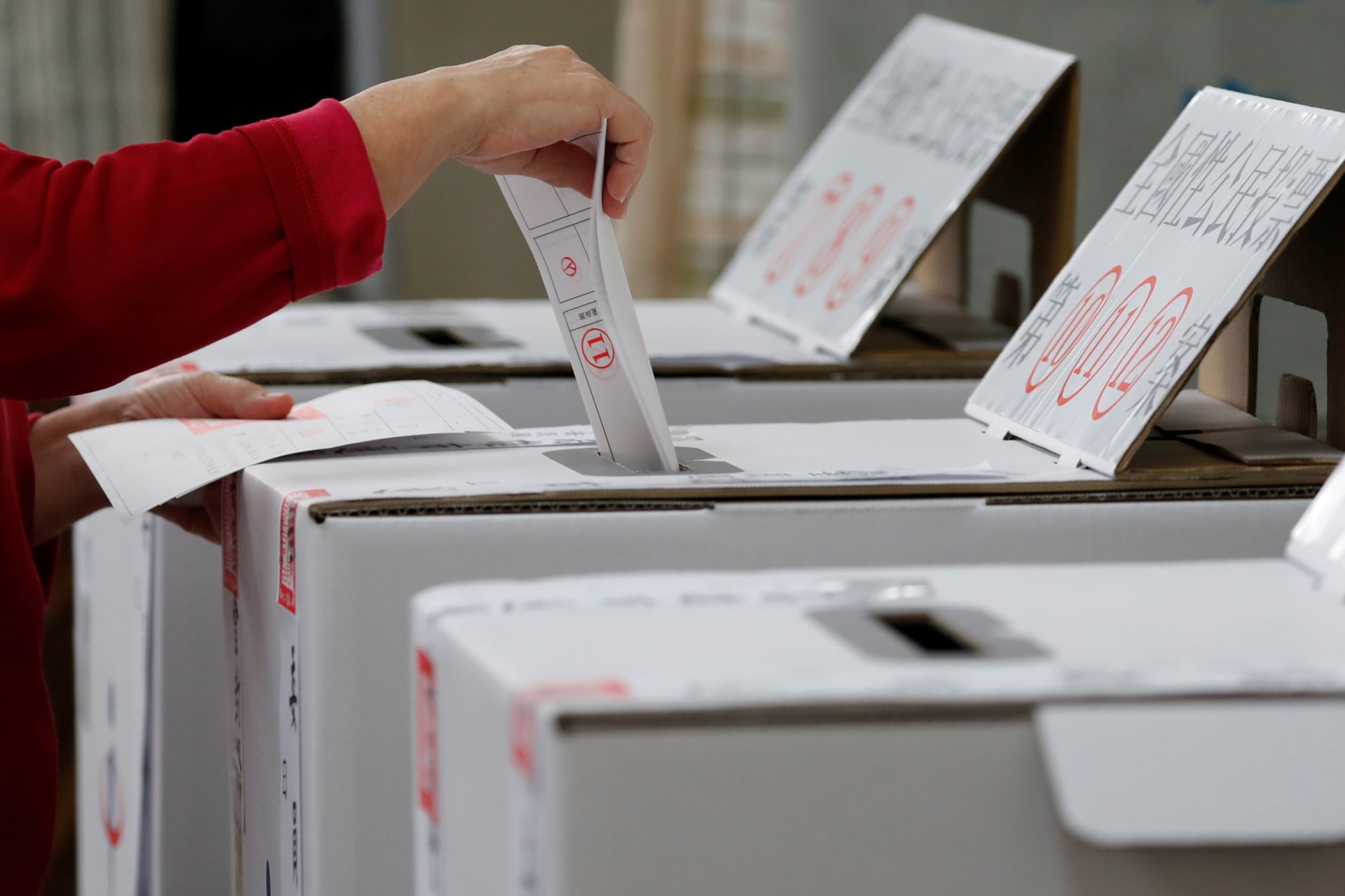 <p>A woman casts her ballots at a polling station during local elections and referendum on same-sex marriage in Kaohsiung, Taiwan on November 24, 2018.</p>
